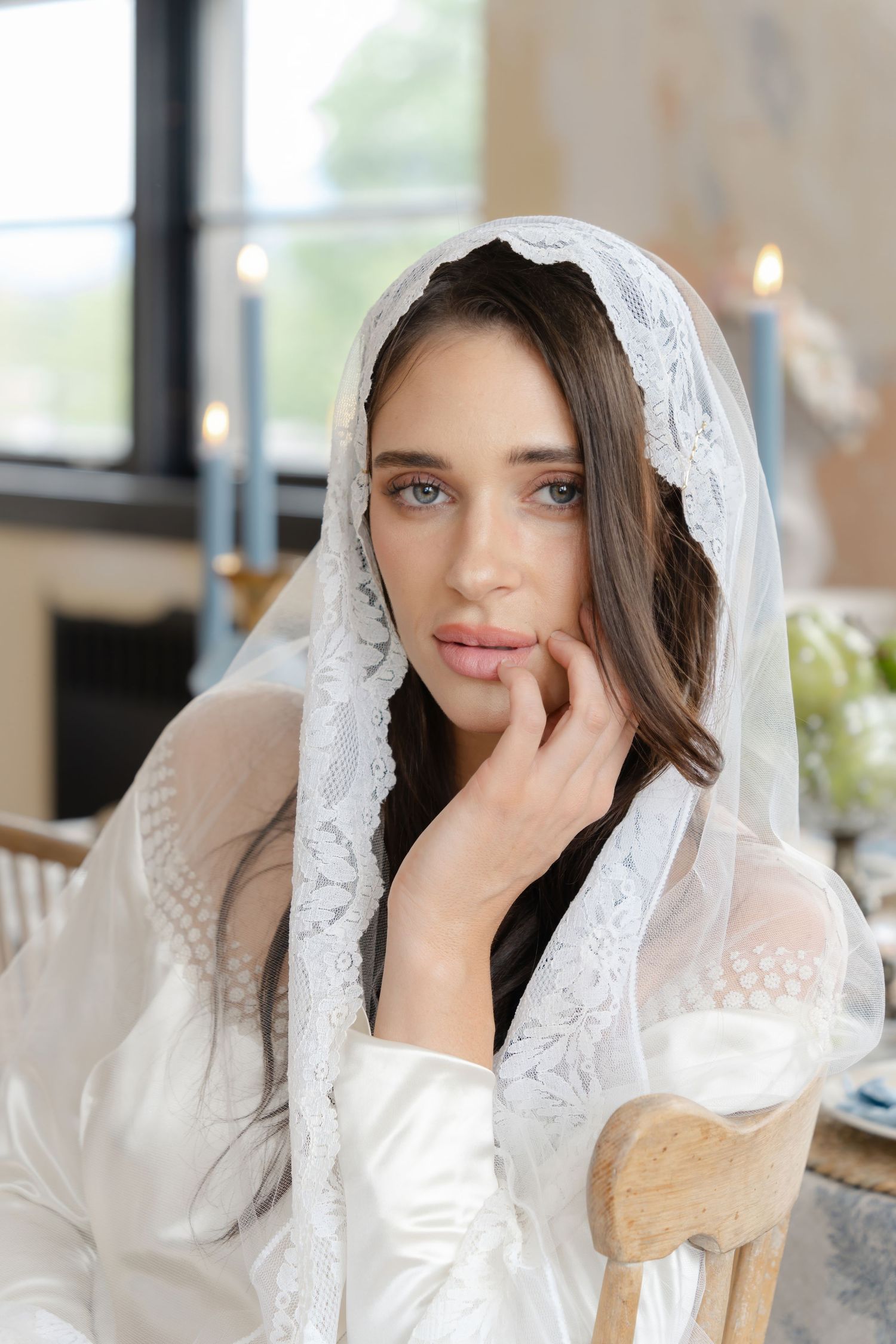Close up portrait showing delicate lace veil details in soft natural window light.