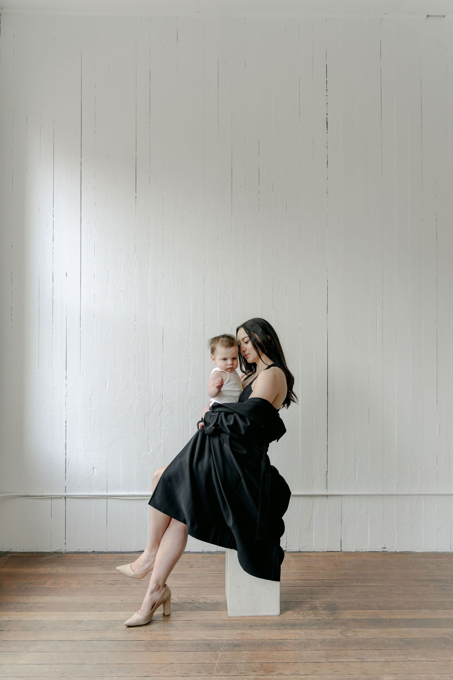 Artistic series of poses on wooden floor showing intimate moments between two people in black and white attire.