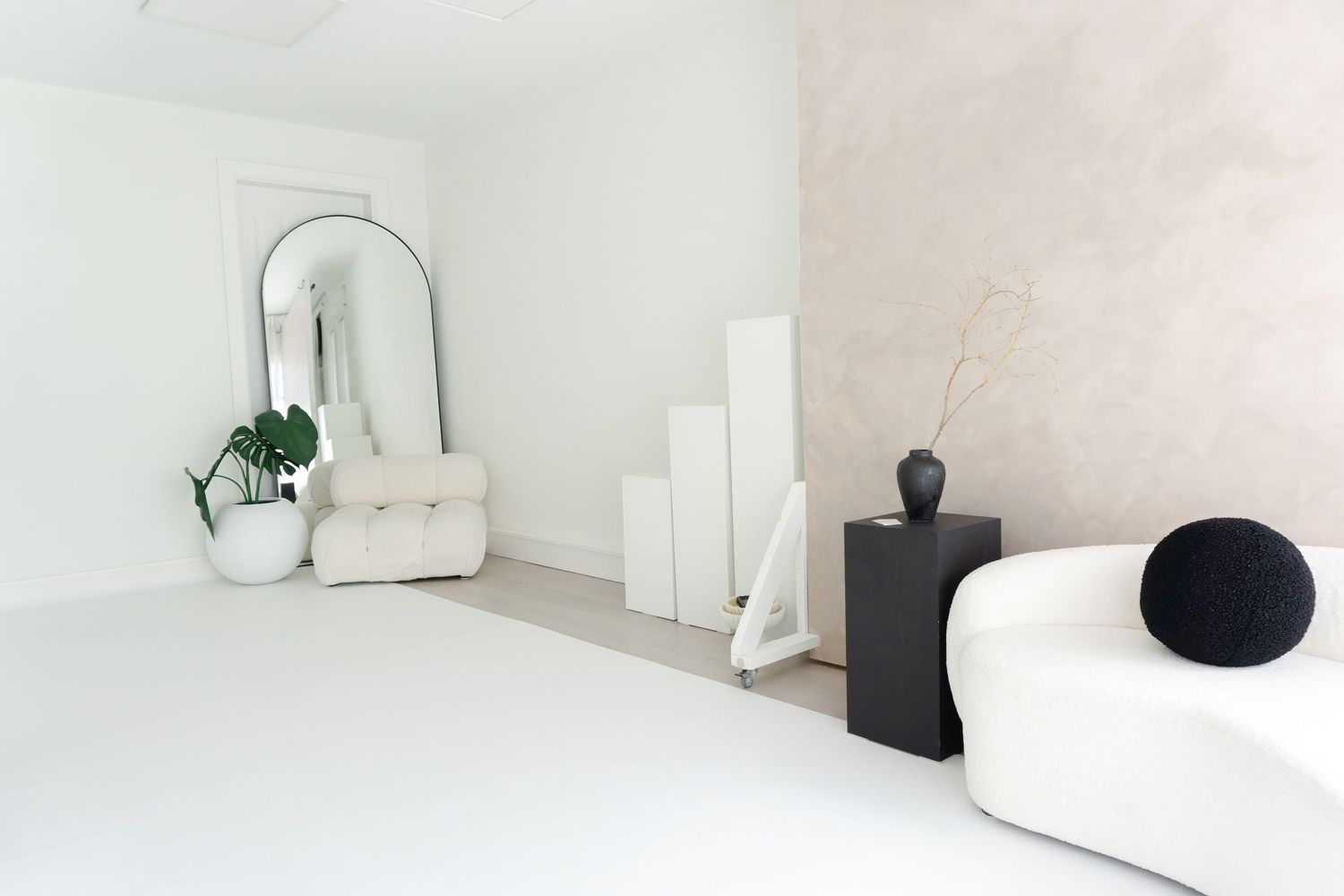 Abstract black and white art pieces arranged on floating shelves in minimalist contemporary gallery space.