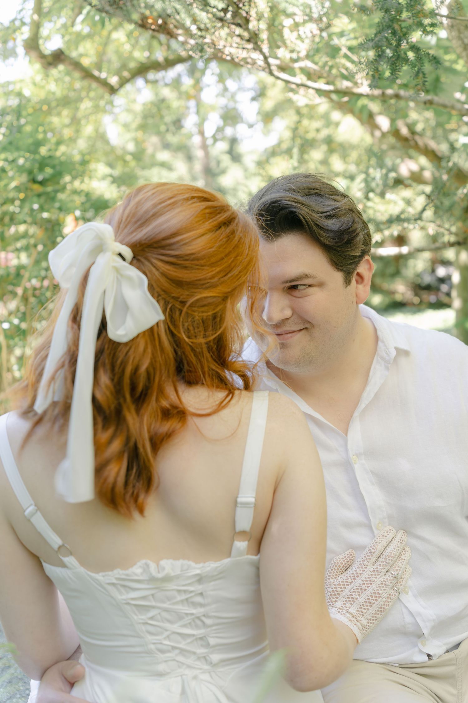 An intimate sequence of photos showing a couple in white clothing sharing tender moments in natural sunlight.