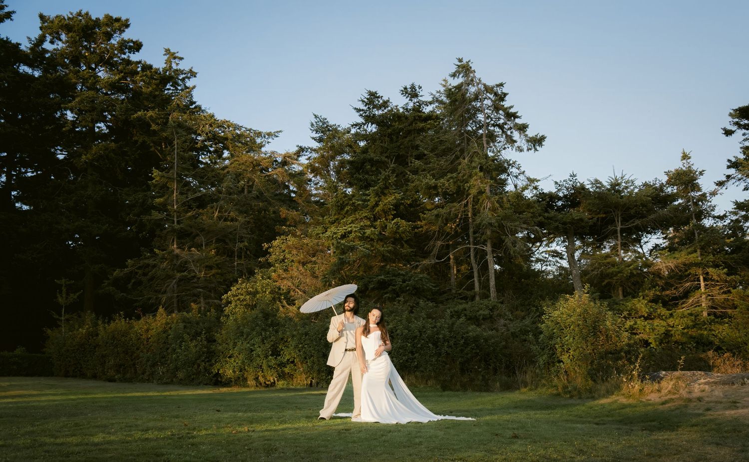 A scenic coastal landscape with evergreen trees and blue sky visible across multiple connected panoramic views.