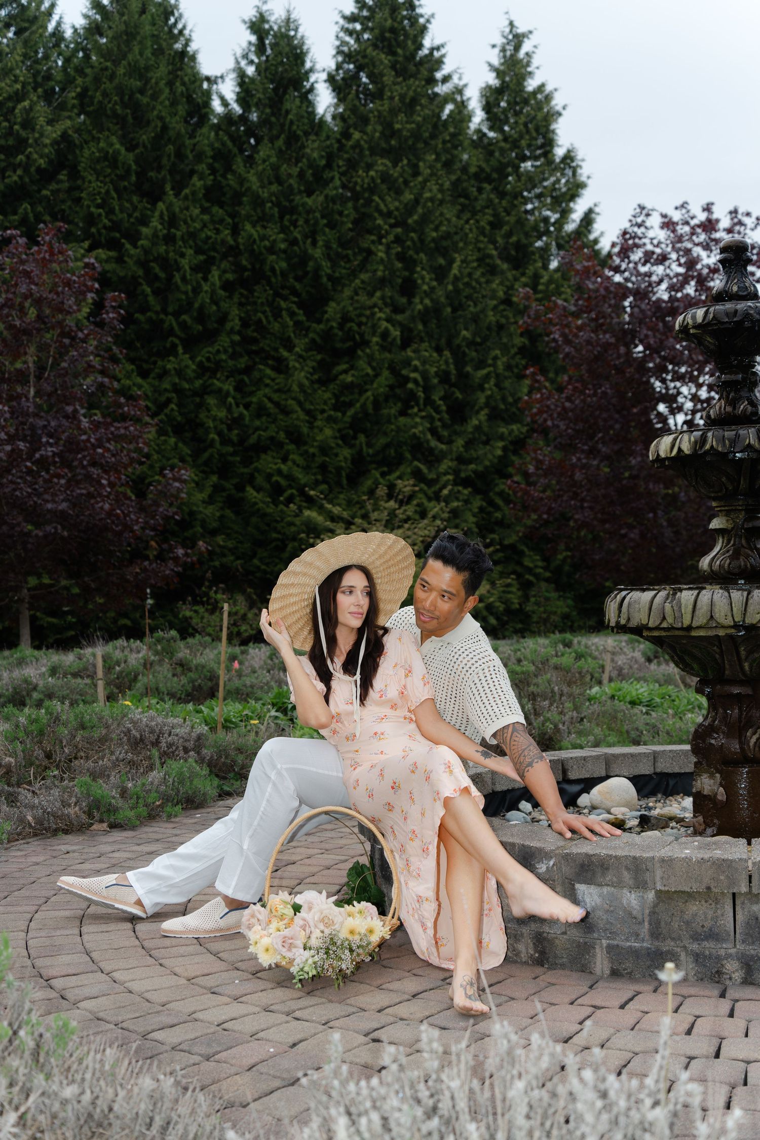A romantic outdoor photoshoot on stone pavers surrounded by evergreen trees.