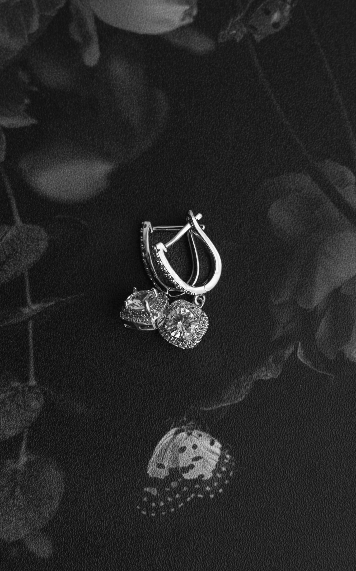 Diamond engagement rings photographed in dramatic black and white on dark background.