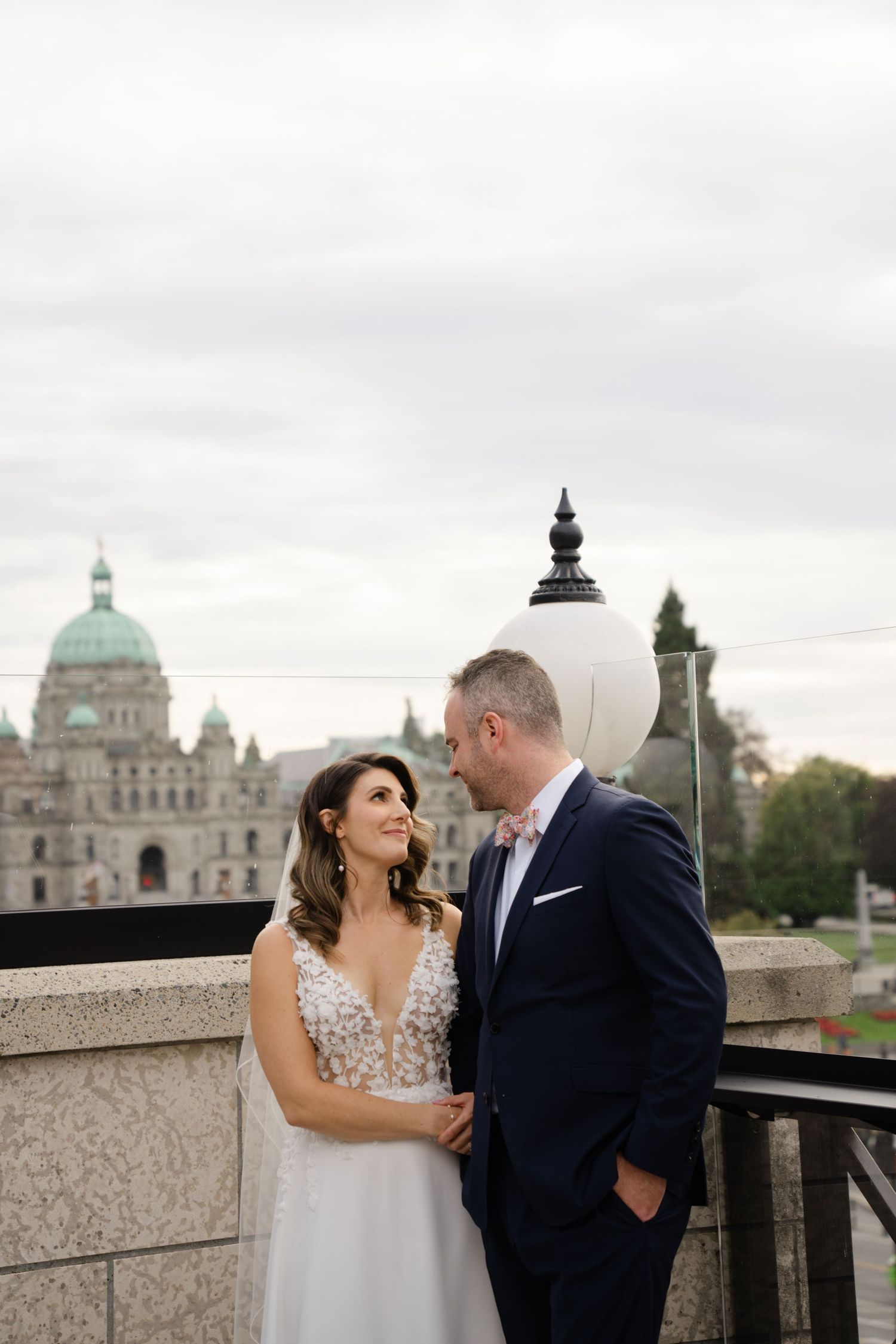 Romantic couple portrait with Victoria Parliament Buildings visible in background.
