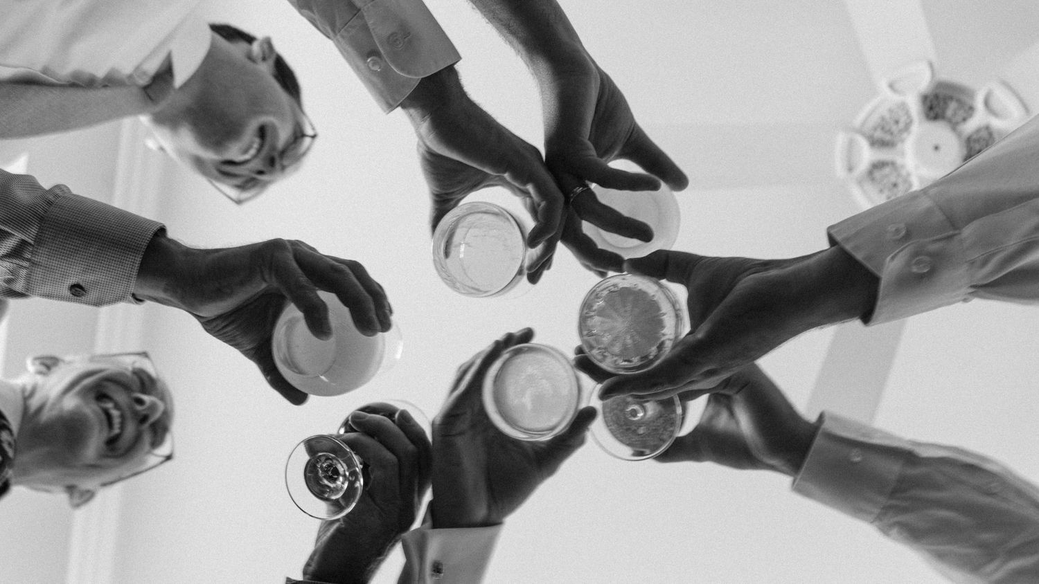 Wedding reception toasting glasses in dramatic black and white sequence.