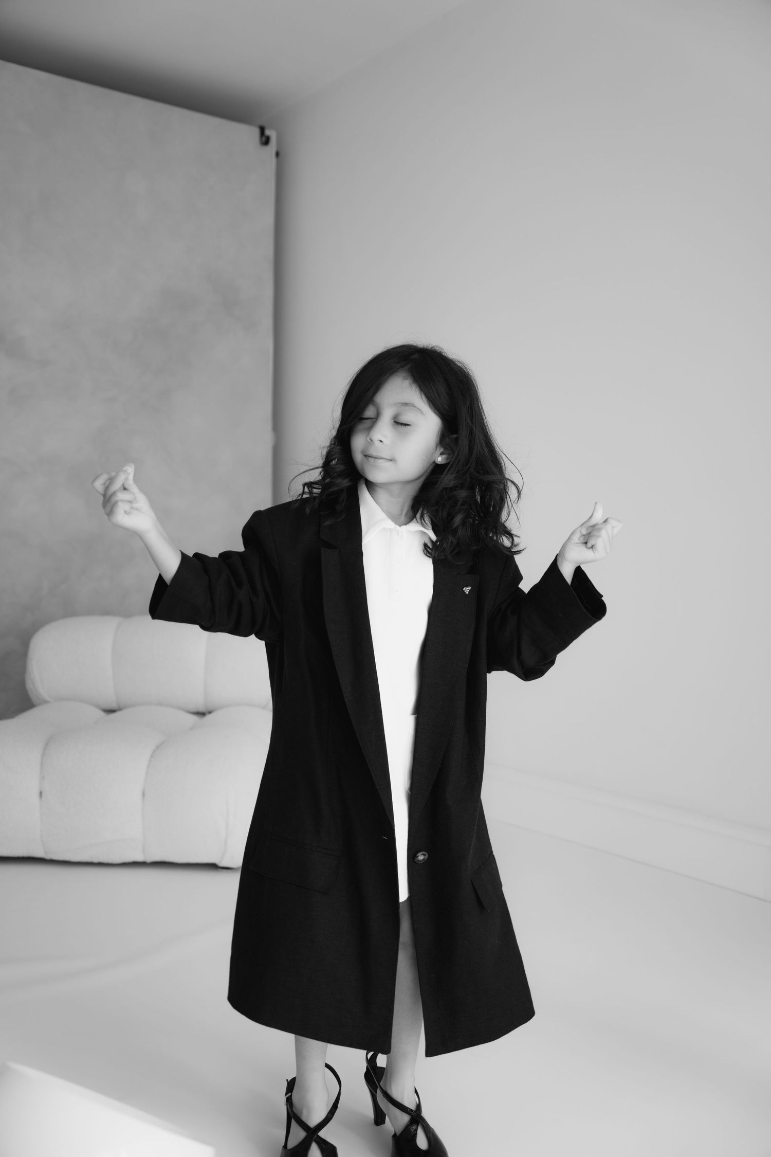 Black and white portrait showcasing expressive pose in long coat.