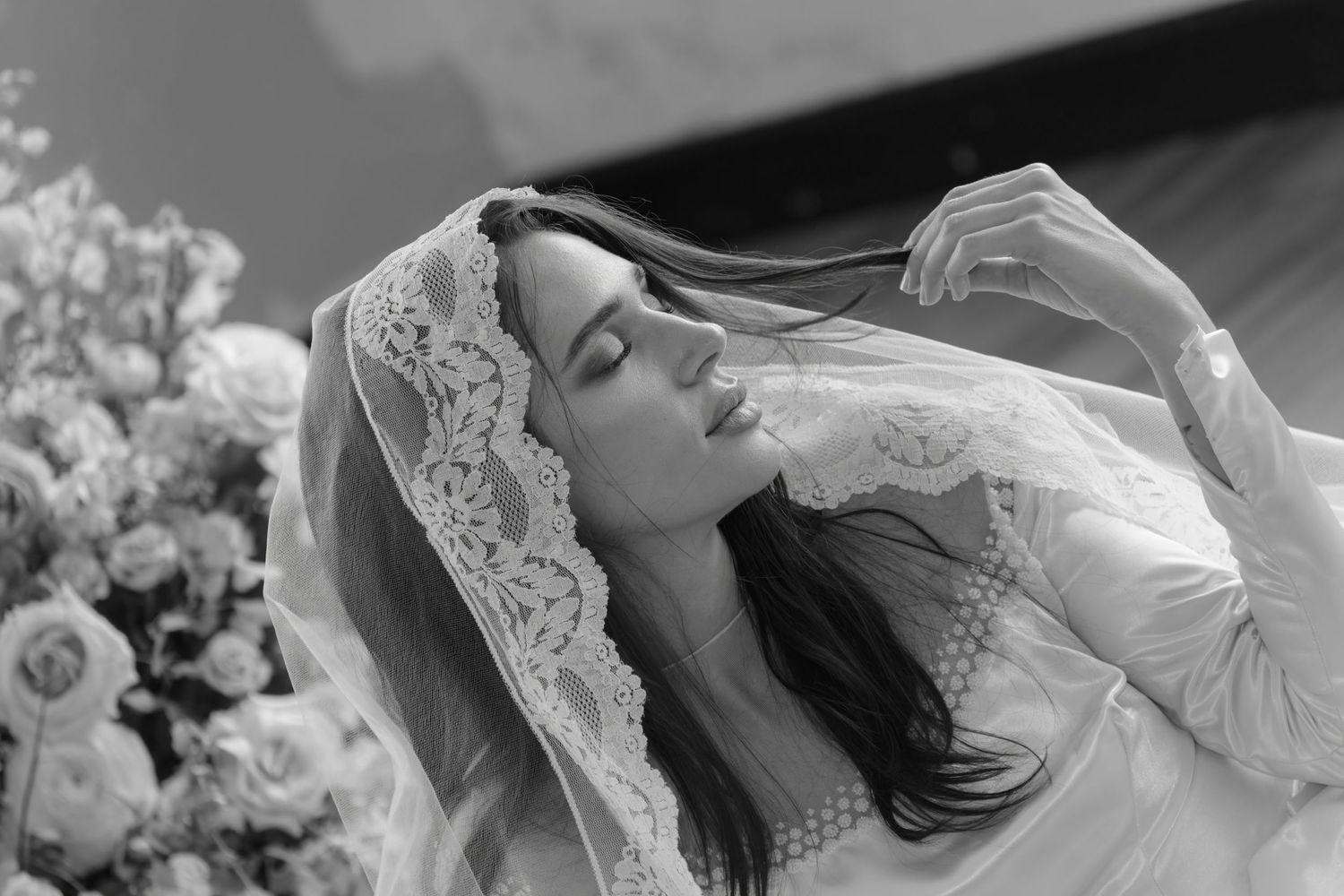 Close-up of romantic wedding moment with delicate lace veil details.