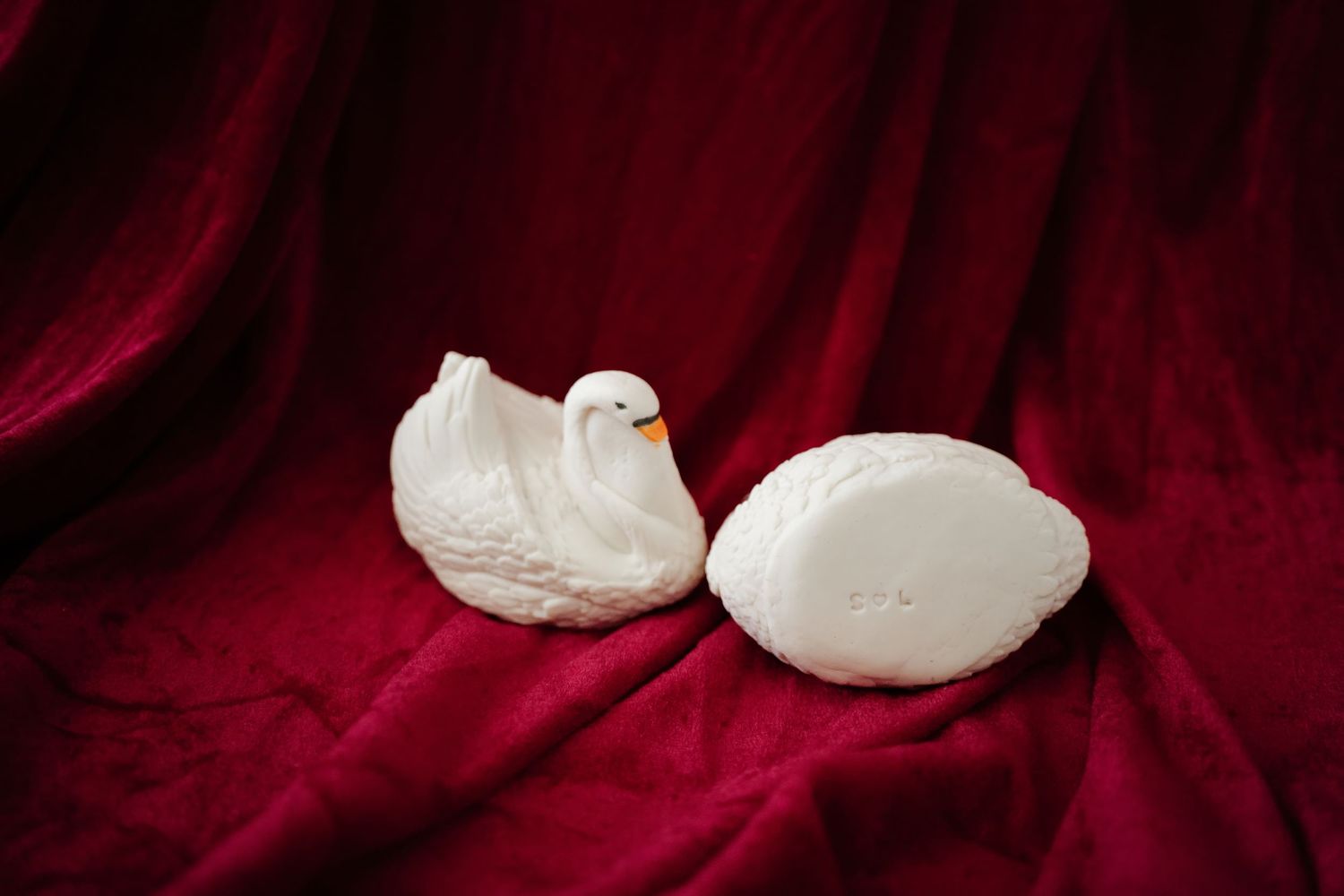 White meringue cookies arranged on a dark red velvet background create an elegant dessert presentation.