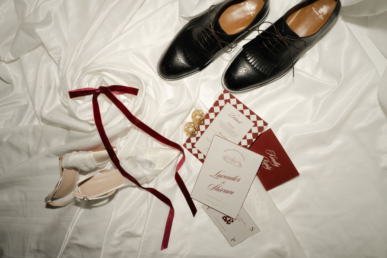 Multiple pairs of elegant leather shoes and boots displayed on a white surface with price tags and ribbons.