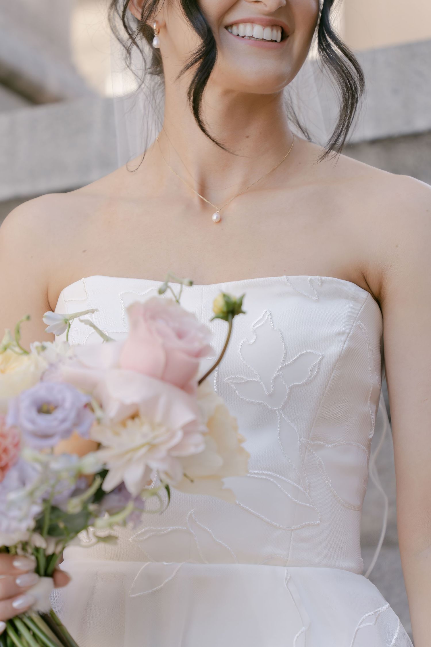 Delicate floral details adorn a white strapless wedding dress with textured fabric.