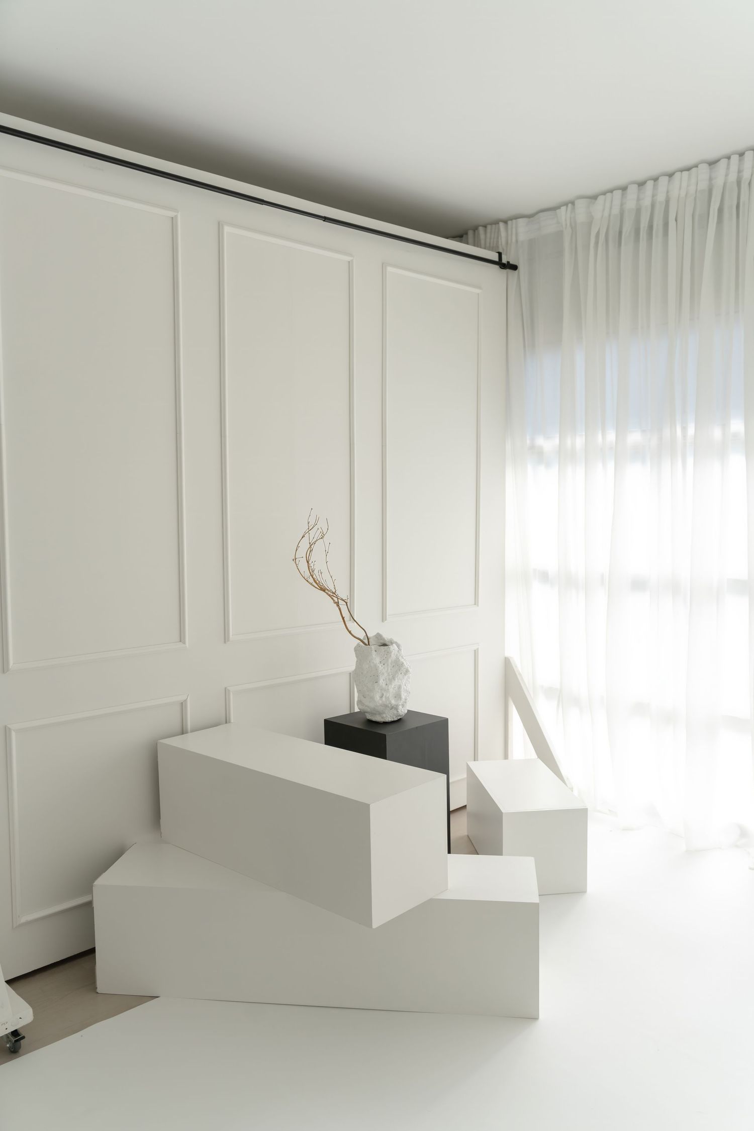 White interior space with stepped display blocks and panel wall detailing.