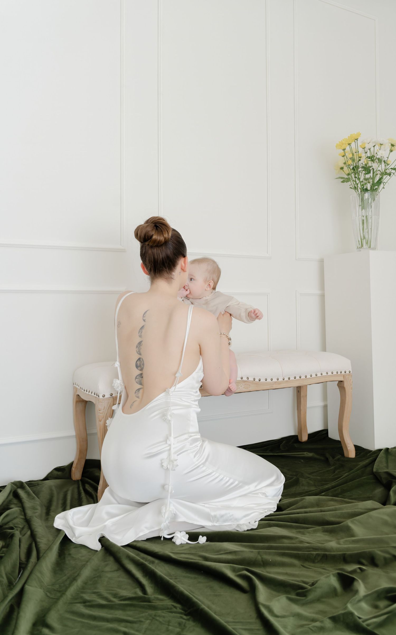 Intimate portrait on olive green bedding with white bedding and natural window light.