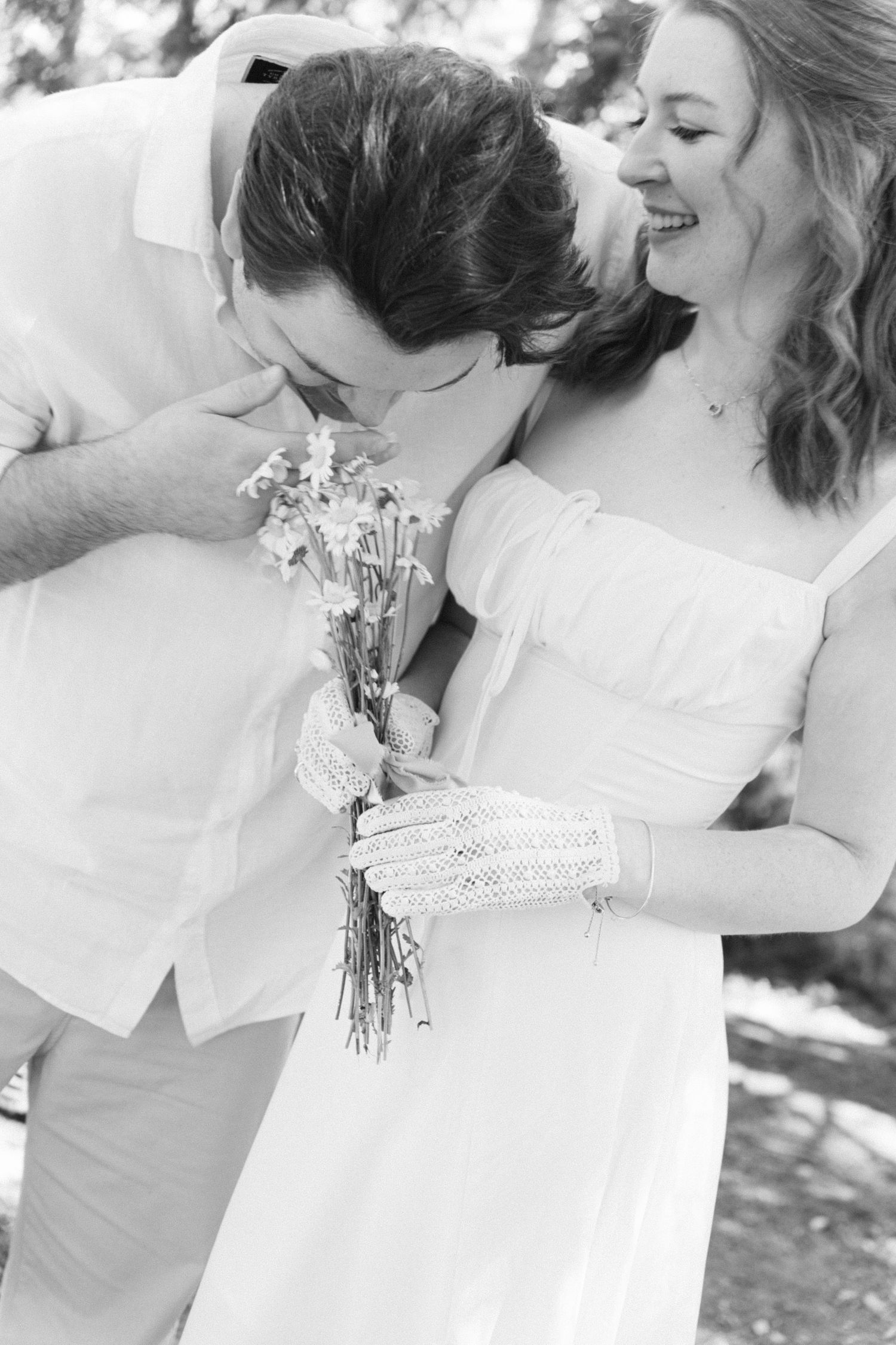 Black and white candid moments of wedding couple embracing with floral bouquet details.