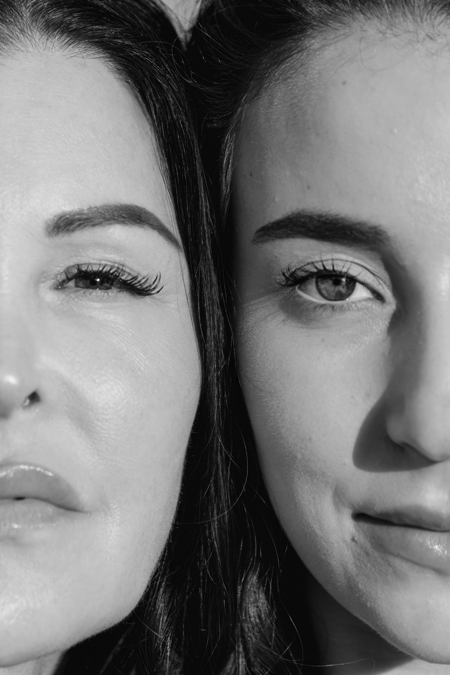Close-up black and white portrait showing two faces side by side.