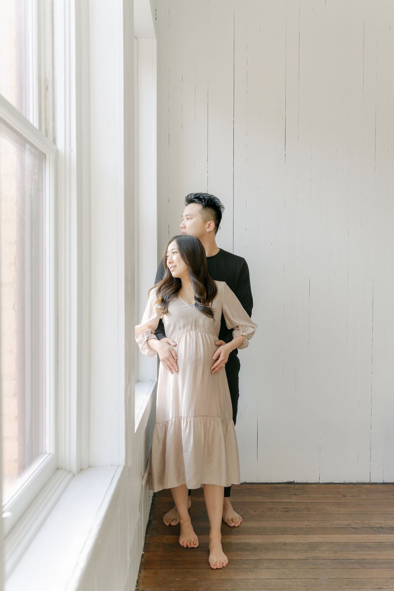 Tender interactions captured in natural light by large windows in a minimal white space.