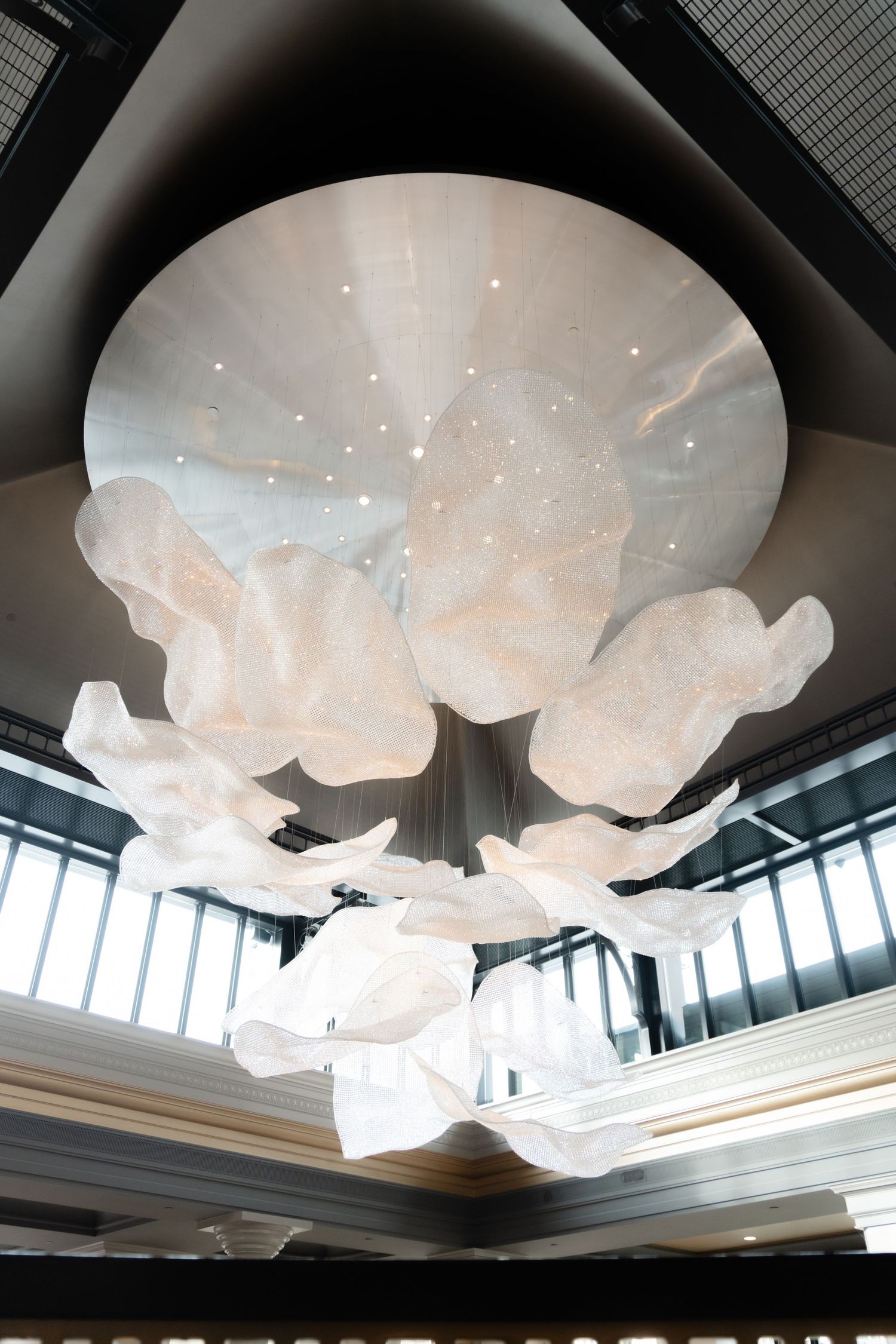 Modern white cloud-like light installations suspended from dark ceiling create dreamy atmosphere at Fairmont Hotel in Victoria, B.C