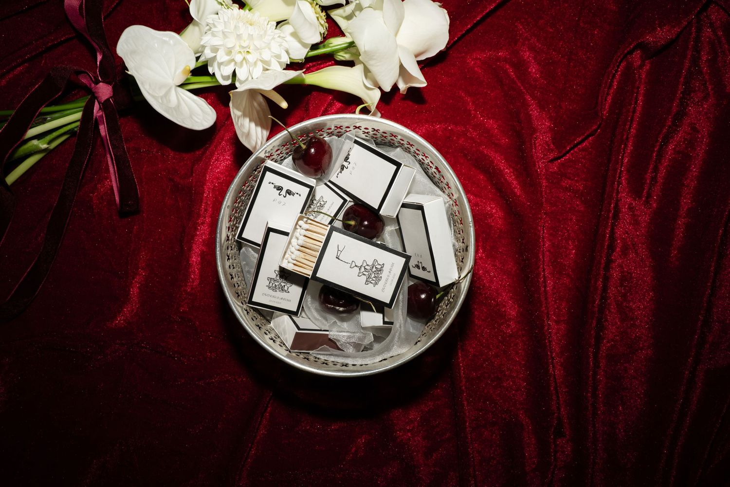 Shiny silver cross pendants and jewelry pieces arranged on deep red velvet fabric.