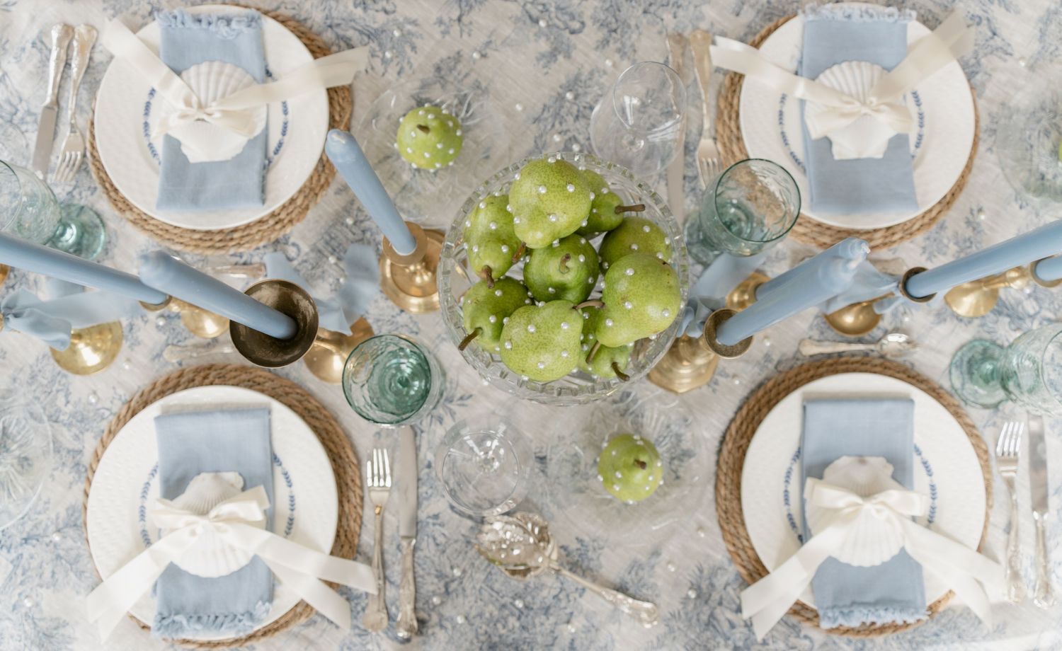 Wedding reception table setting with blue accents, vintage plates, crystal glasses and hydrangea centerpieces.