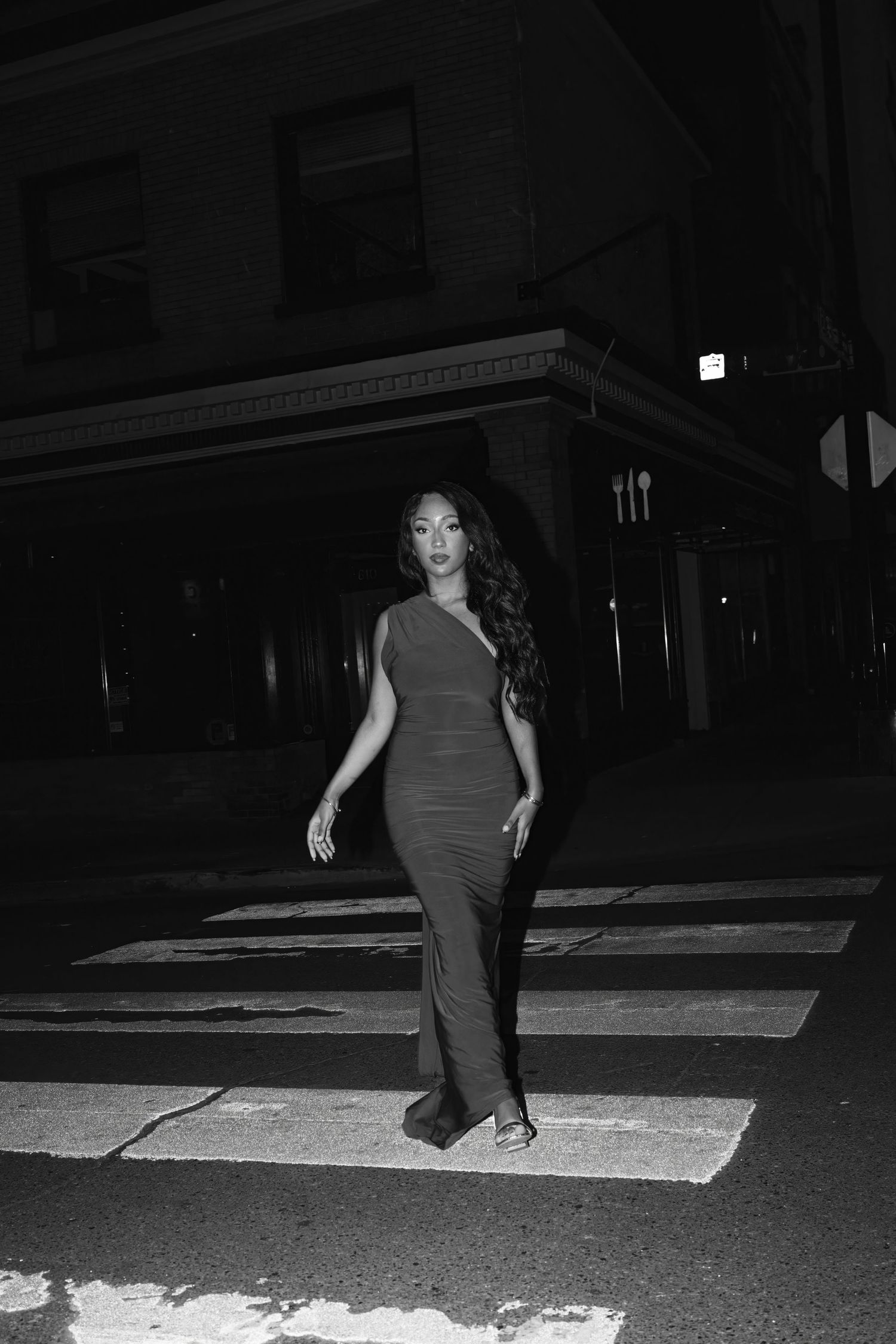 Person dancing in a dark parking lot at night.