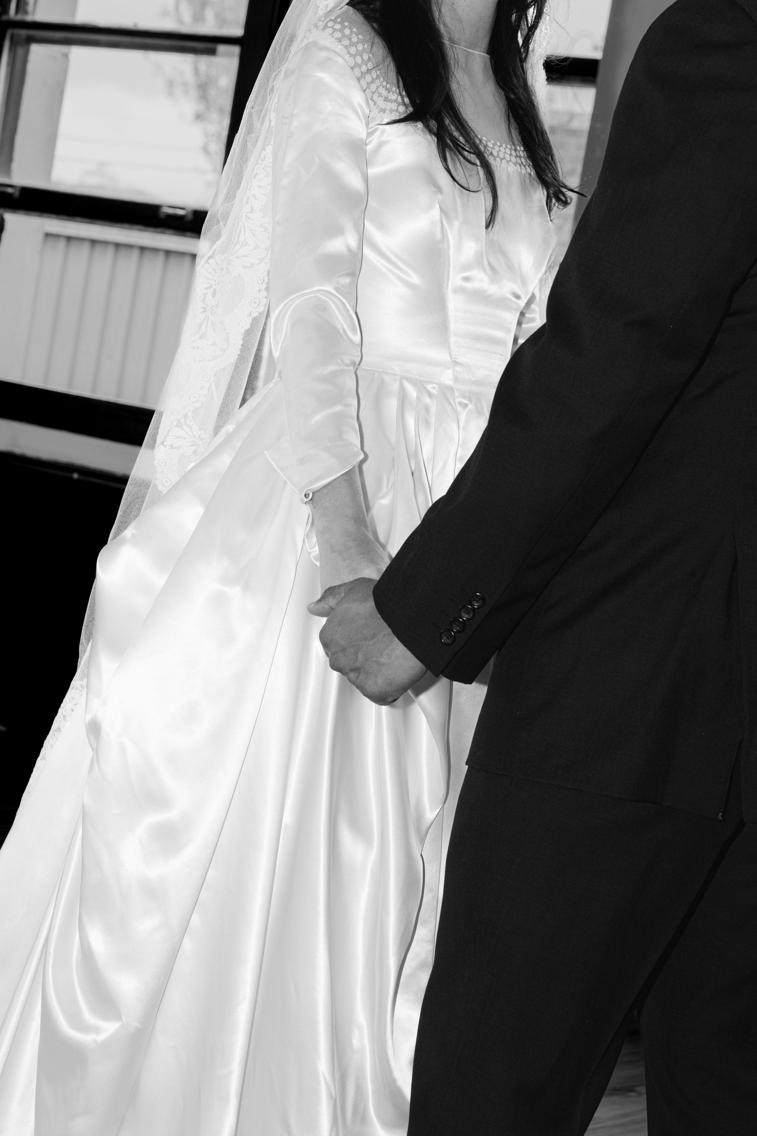 Black and white wedding photo showing contrast between white bridal gown and dark suit.