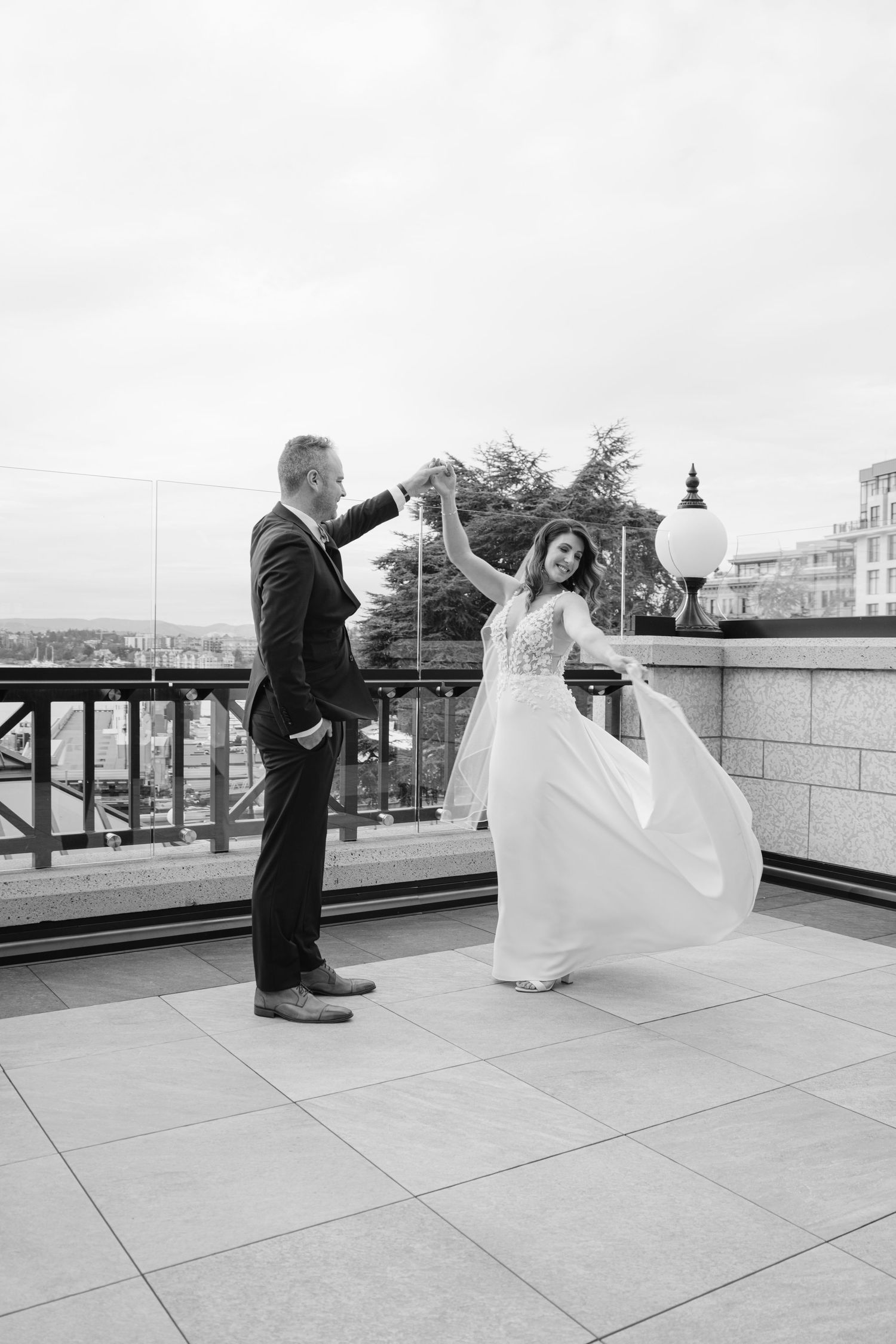 Black and white sequence shows playful first look moment between couple on rooftop.