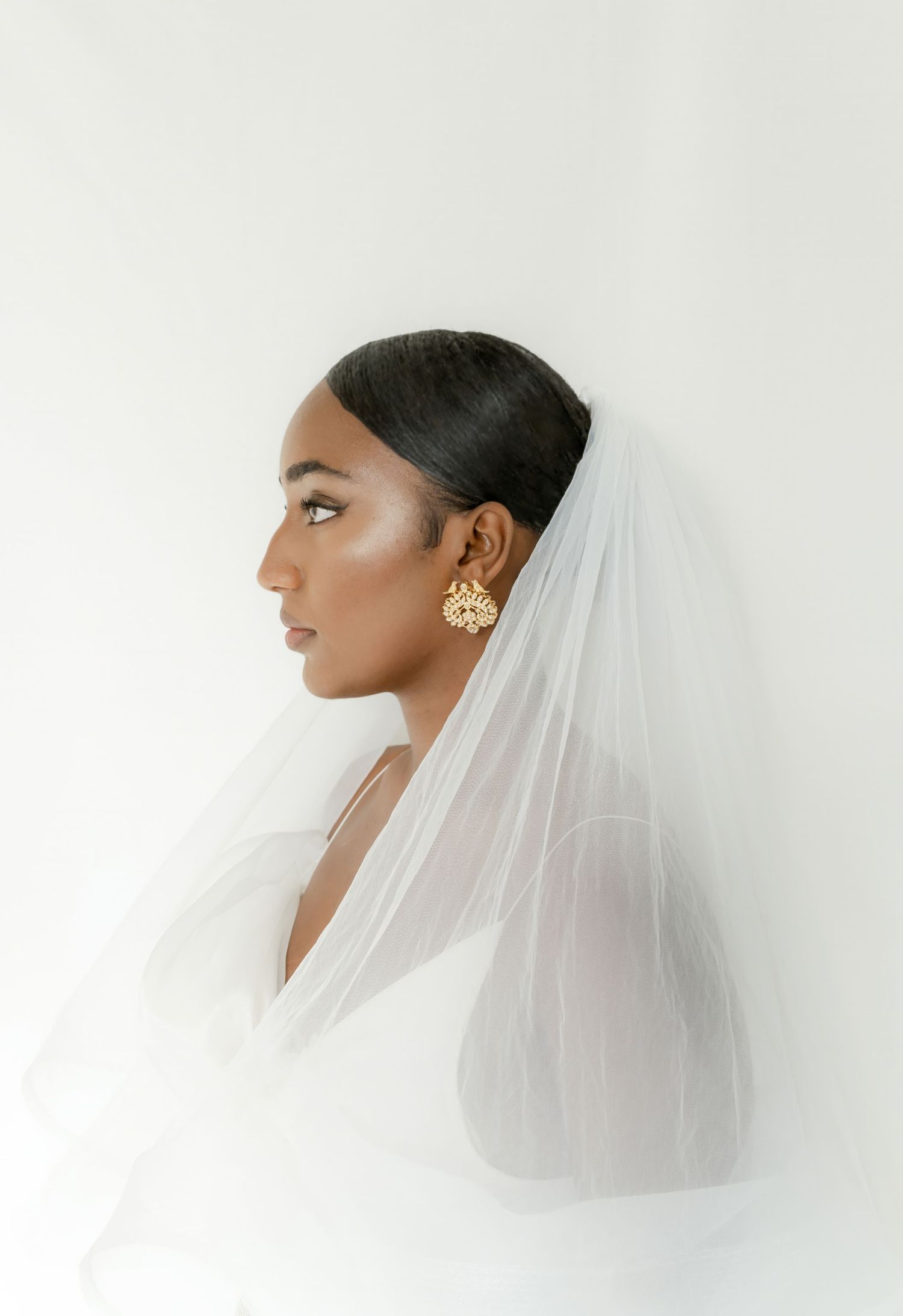 Profile views of elegant bridal portraits with delicate white veil against minimal background.