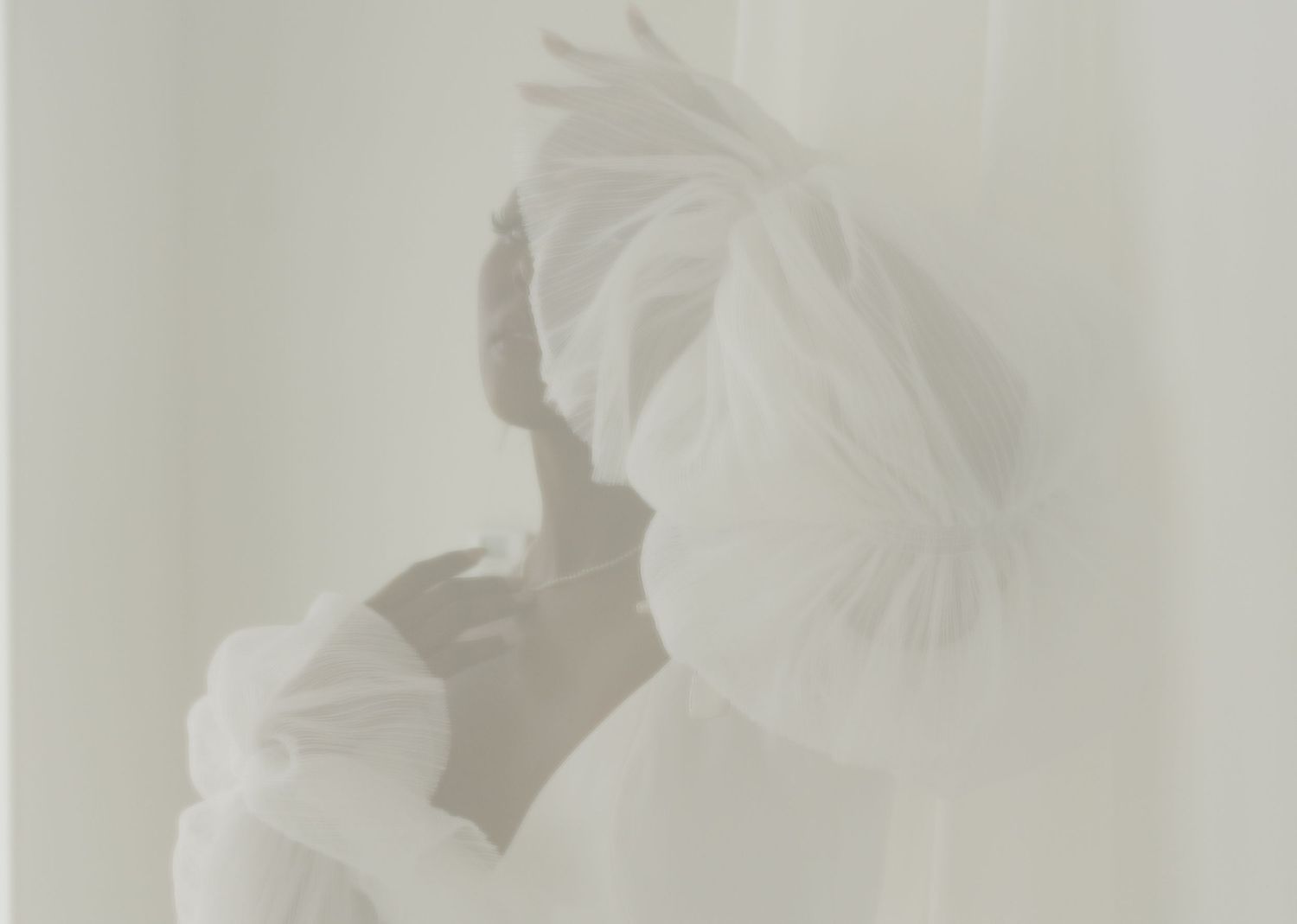Soft focus artistic wedding portraiture featuring ethereal white veils and romantic lighting.