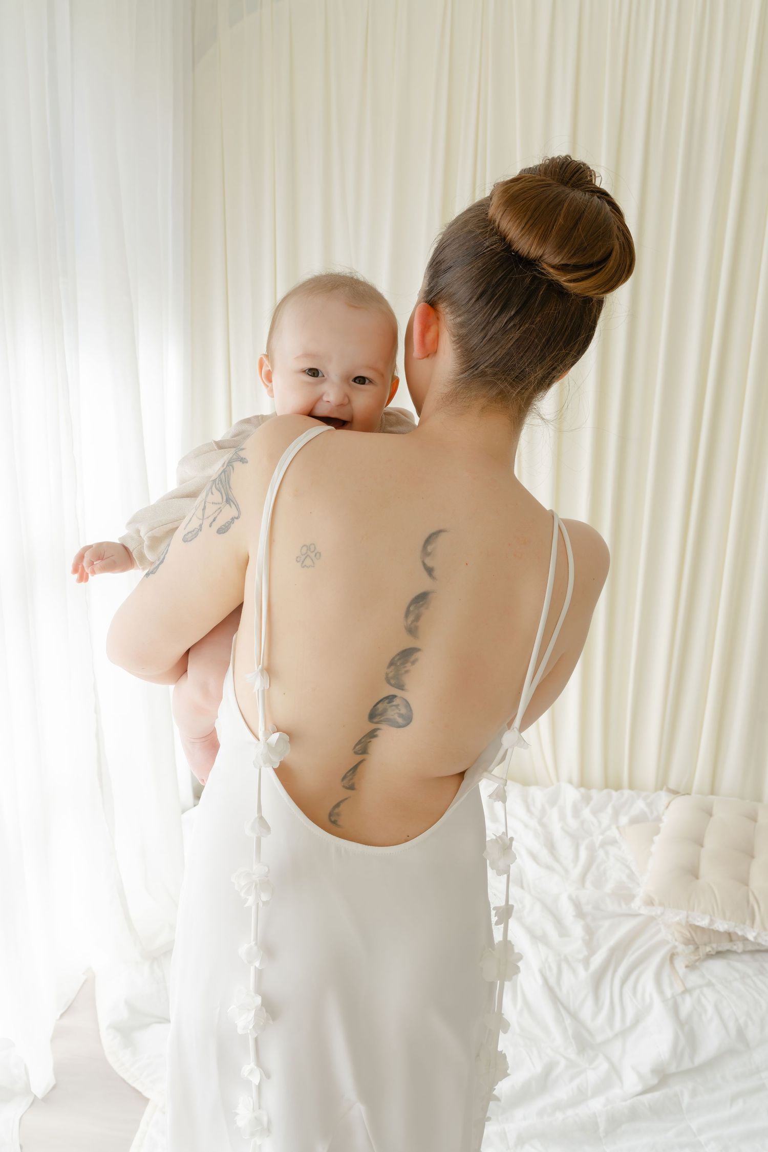 Artistic photographs showing intricate back tattoos and white camisole in natural lighting.