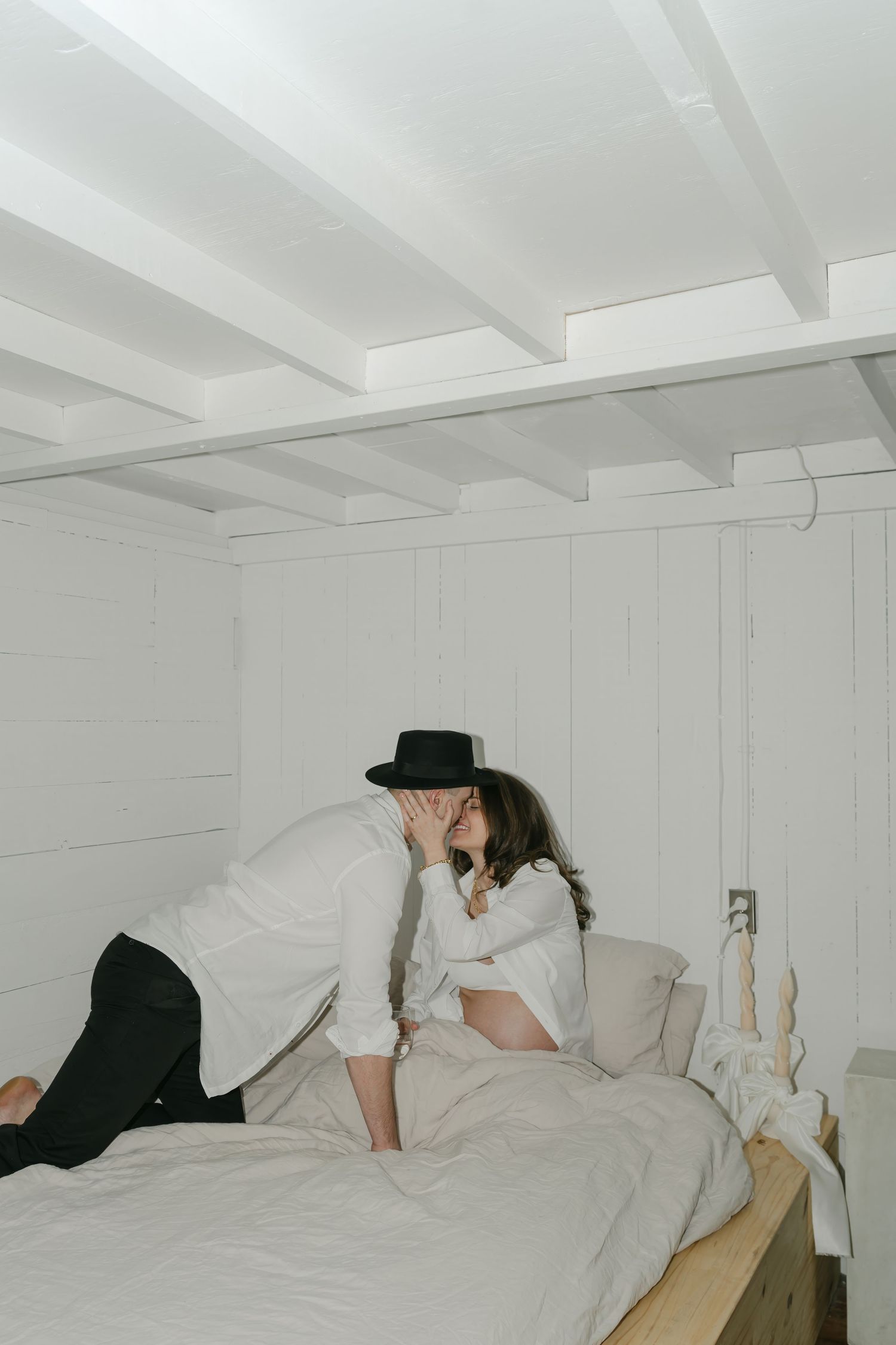 Candid moments captured on white bedding showing relaxed poses in natural light.