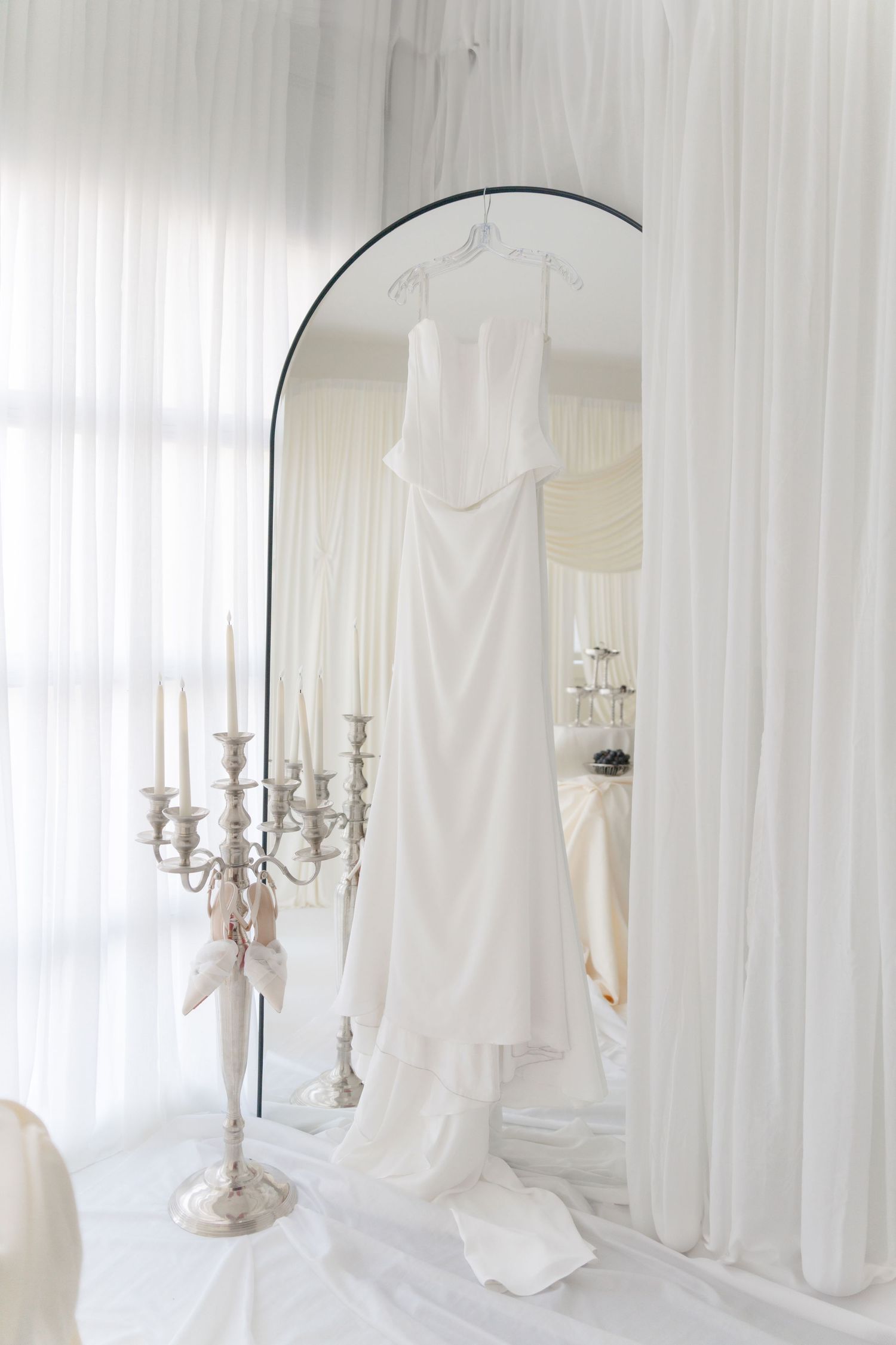 White candelabra stands elegantly against sheer curtains in a bright, airy room with soft natural lighting.