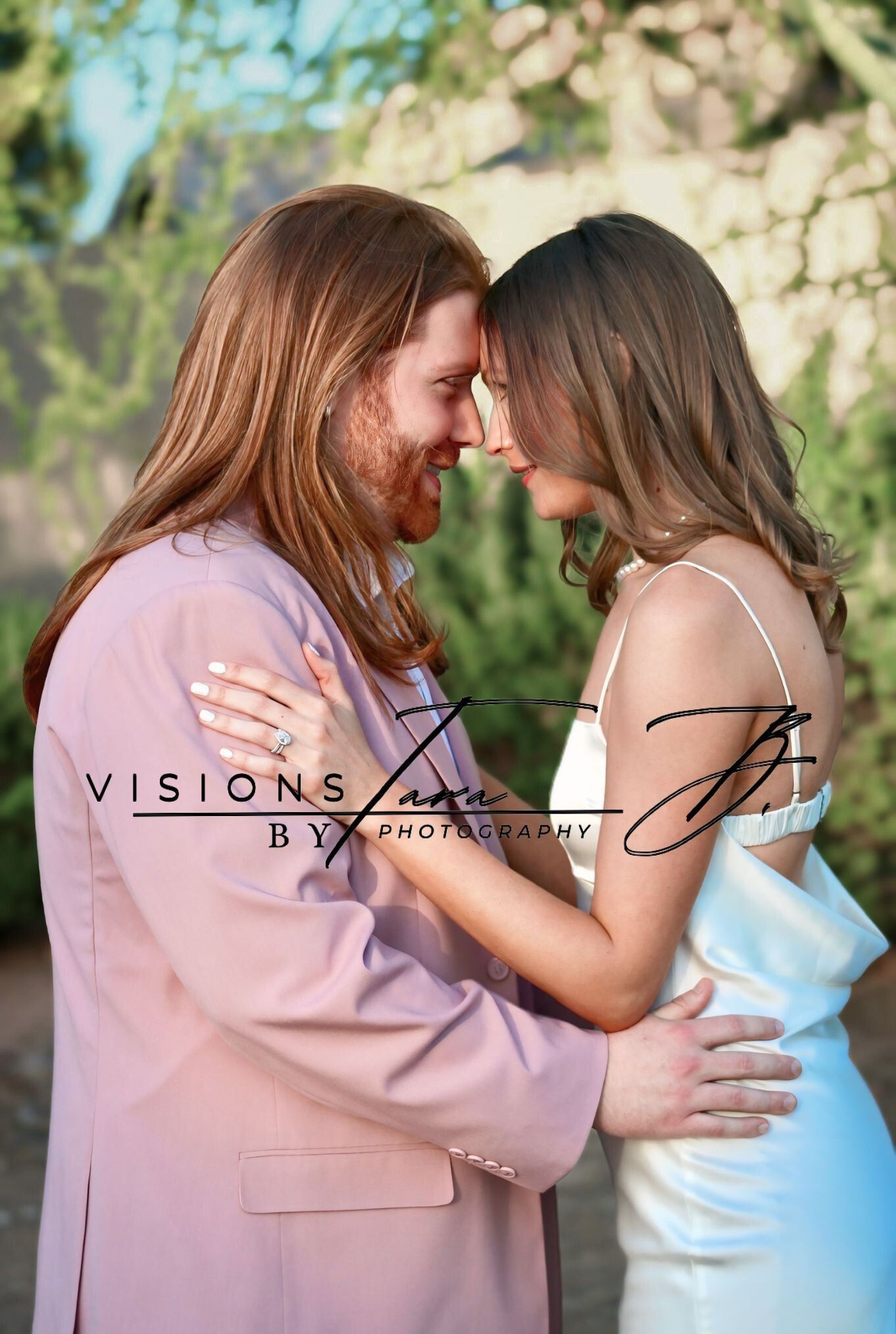 Engaged couple shares an intimate moment in a soft, natural setting.