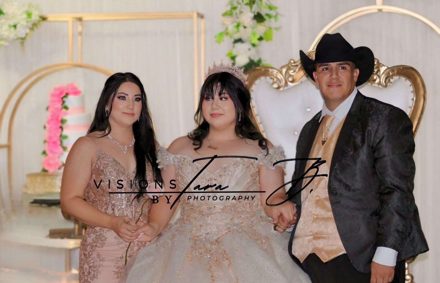 Quinceañera posing with her family in elegant formal attire, standing together in front of a beautifully decorated backdrop.