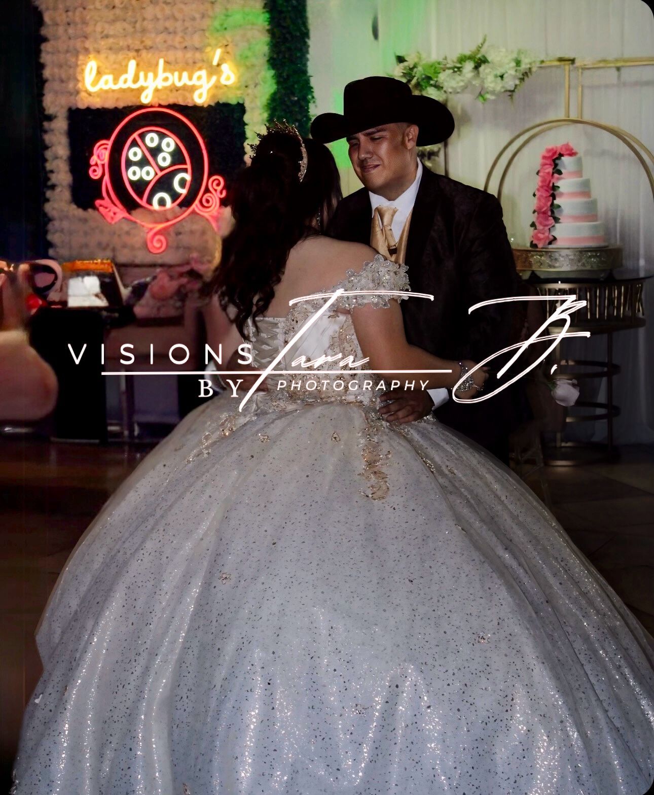 Quinceañera dancing with her father under colorful lights, sharing a heartfelt moment during the celebration.