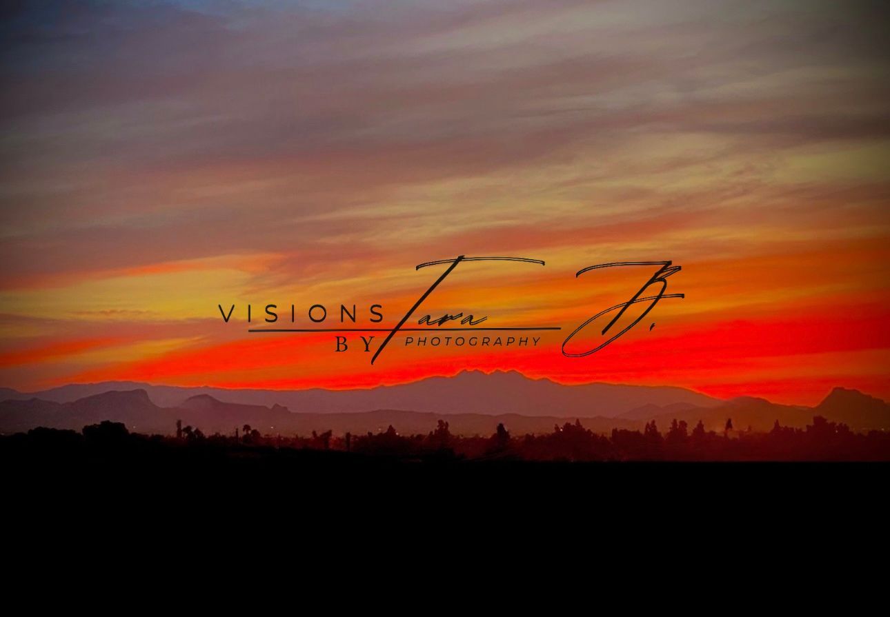 Vibrant sunset with deep reds, oranges, and purples glowing over distant desert mountains as the last light fades.