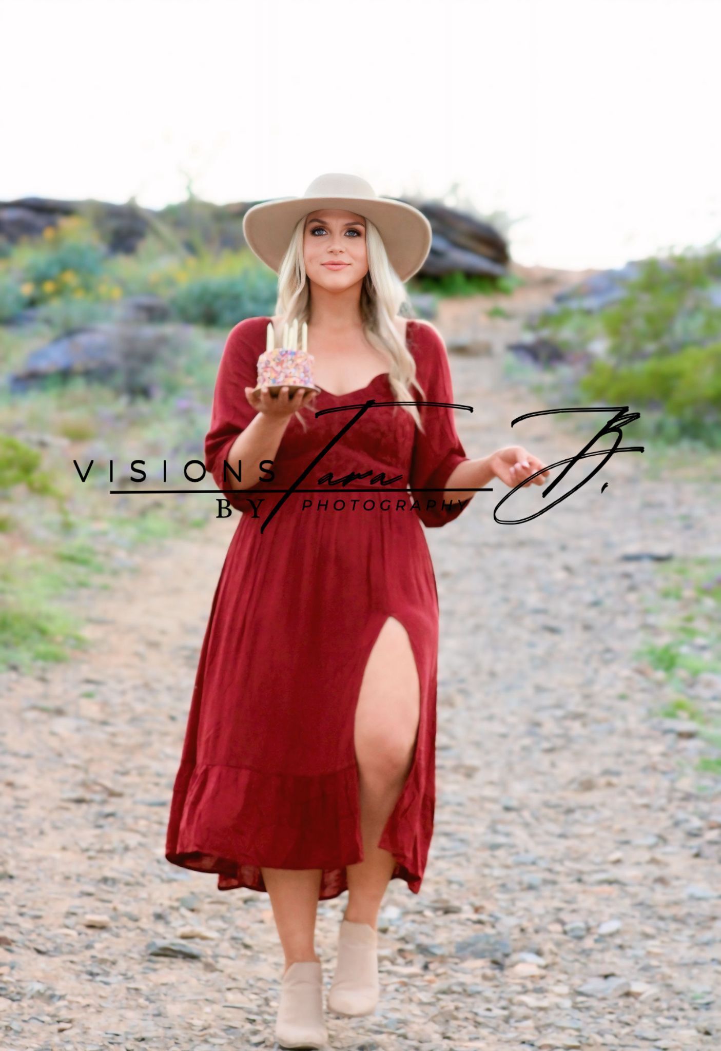 Woman in a red dress walking through the desert, smiling while celebrating her birthday in warm natural light.