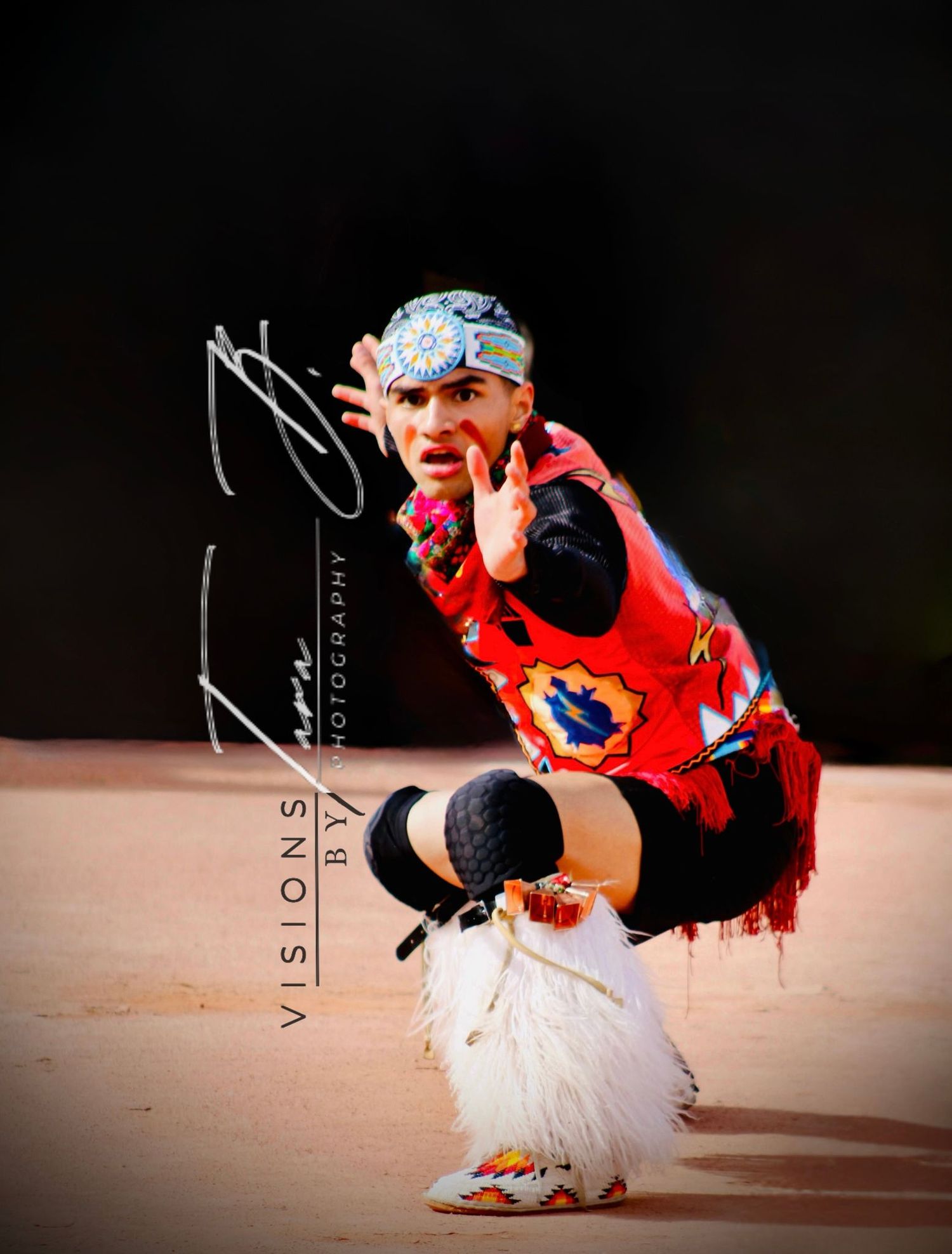 Traditional dancer in vibrant regalia striking a strong power pose, showcasing cultural pride and focused energy.