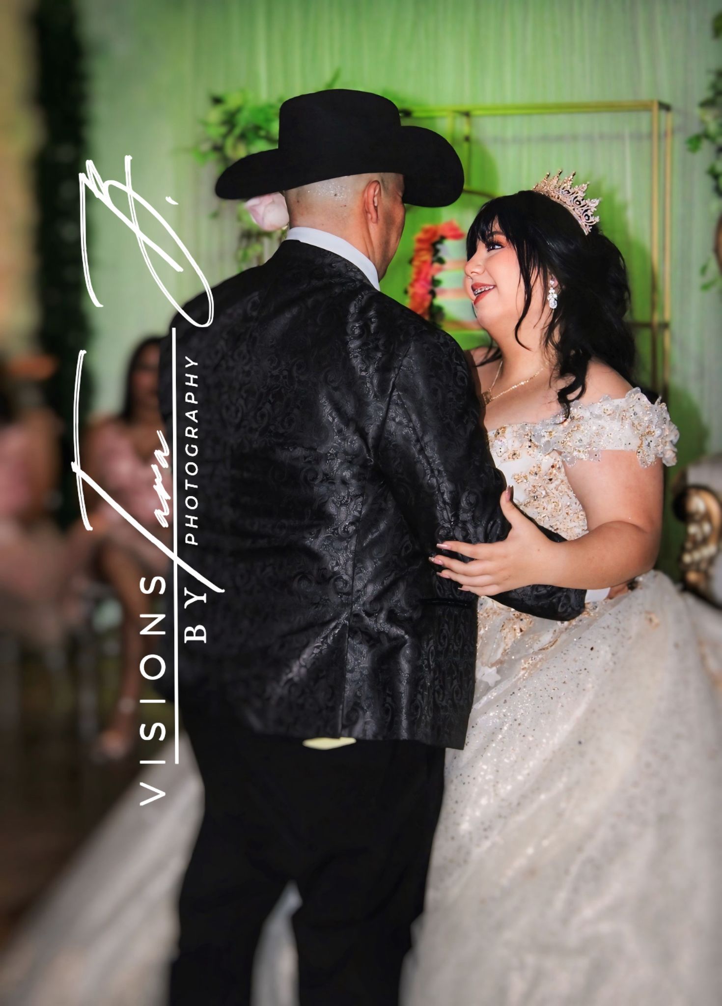 Emotional daddy-daughter dance moment at a wedding, with the bride smiling up at her father under warm reception lighting.