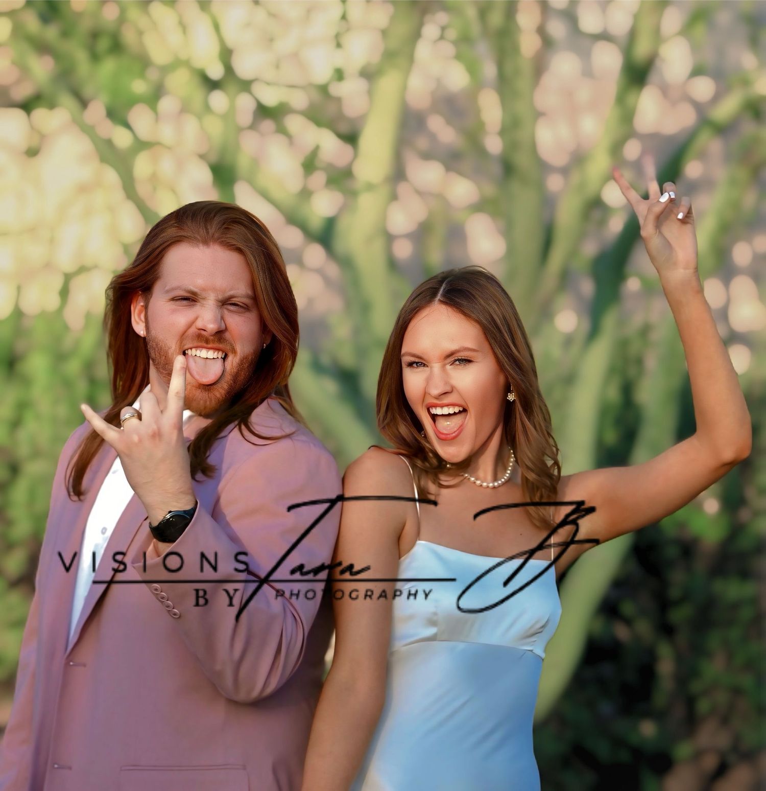 Couple smiling and celebrating together outdoors, raising their hands in joy during a lively moment.