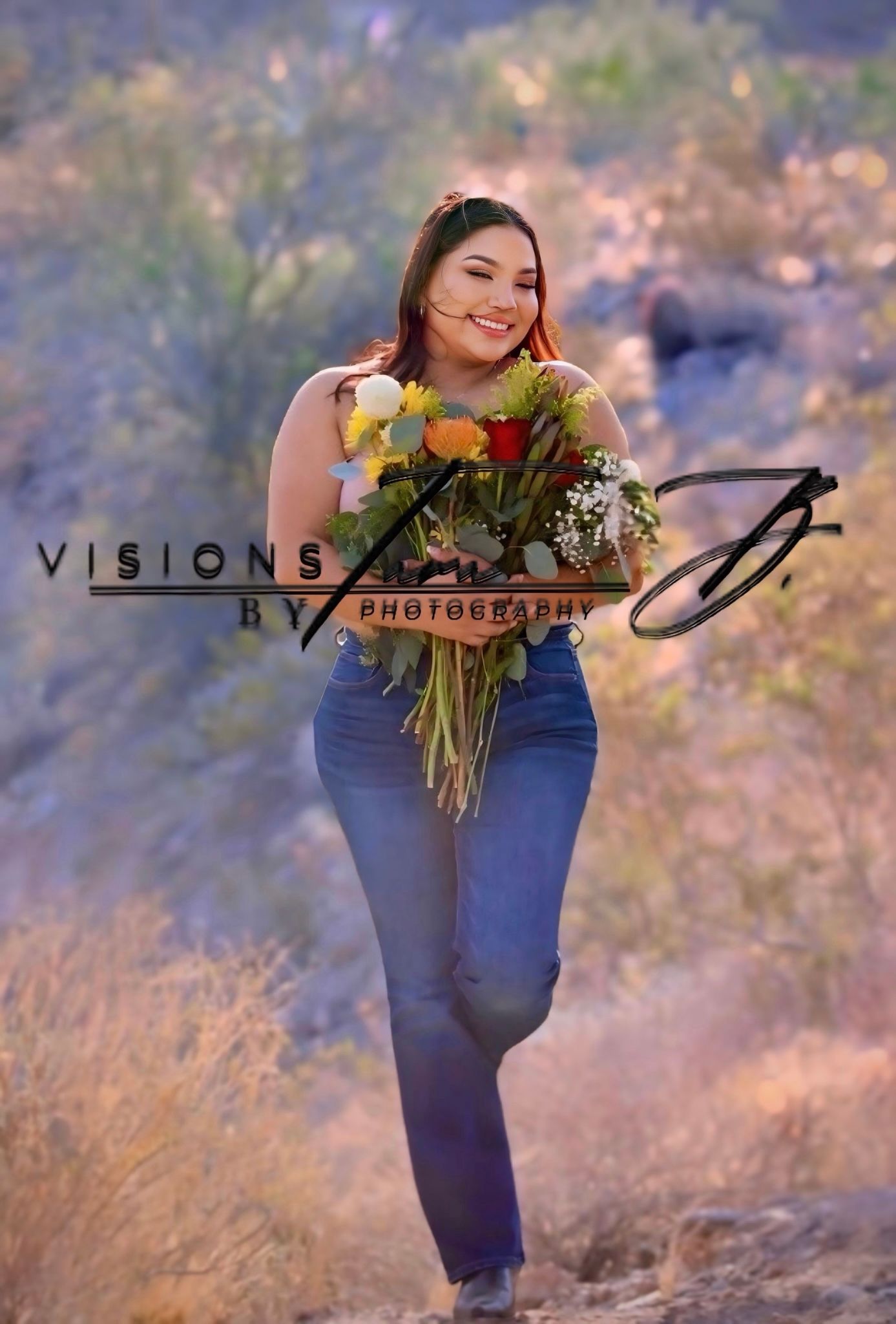 Woman walking through golden brush, holding sunflowers with a soft smile.