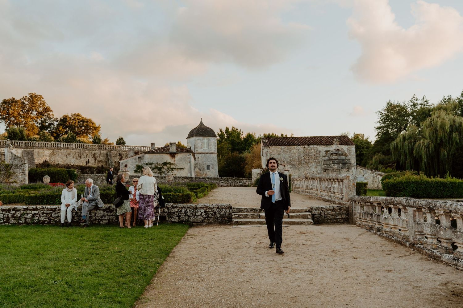 Invité marchant dans l'allée du parc du château en fin de journée