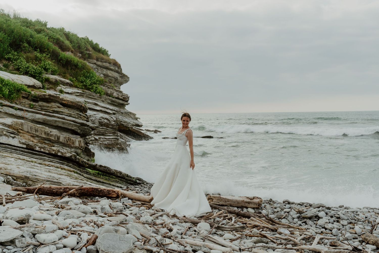 Vue sur des falaises côtières et un e mariée en robe de mariée Caillaud Paris Saint Jean de lux Ciboure