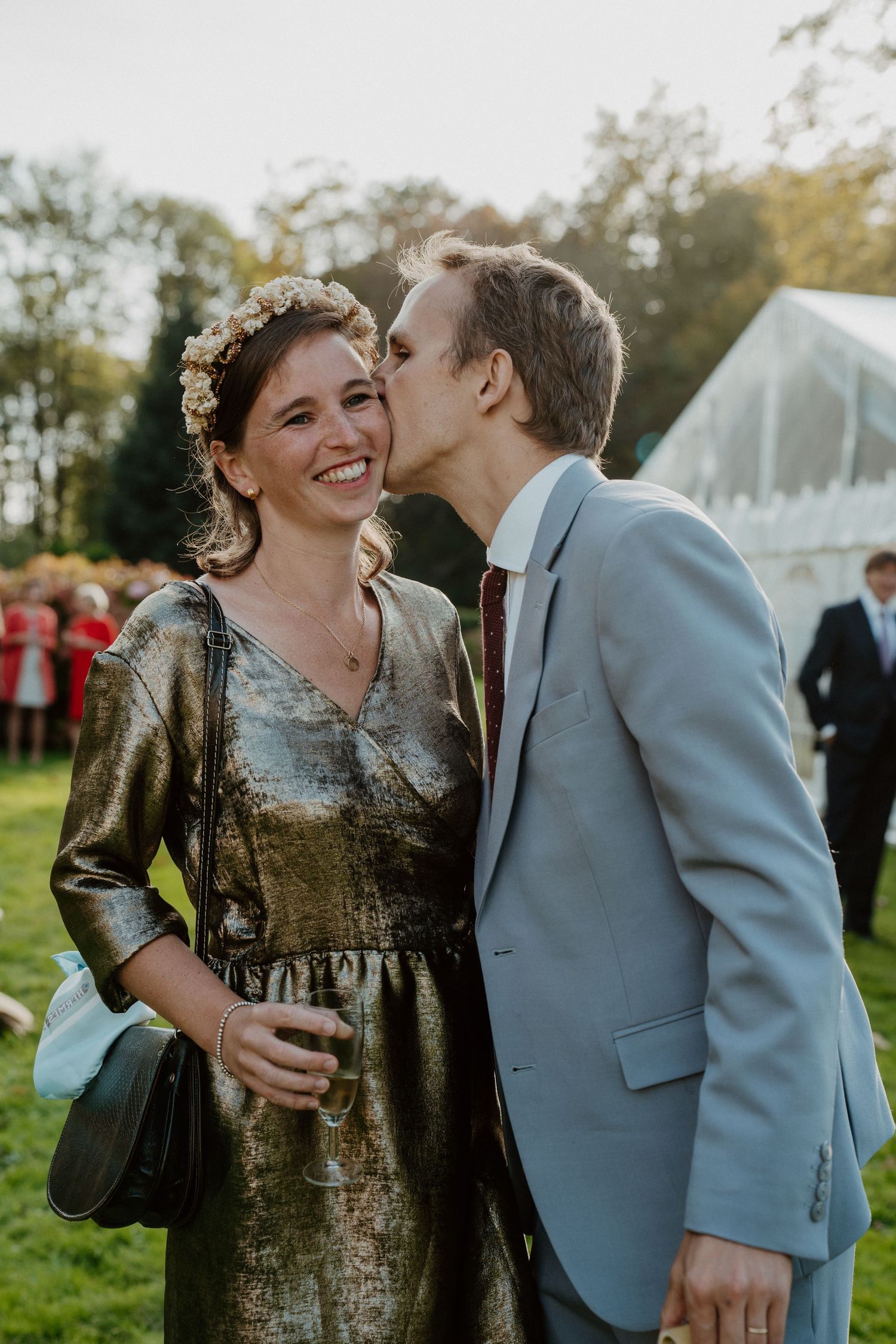 Couple s'embrassant tendrement, robe dorée et costume gris