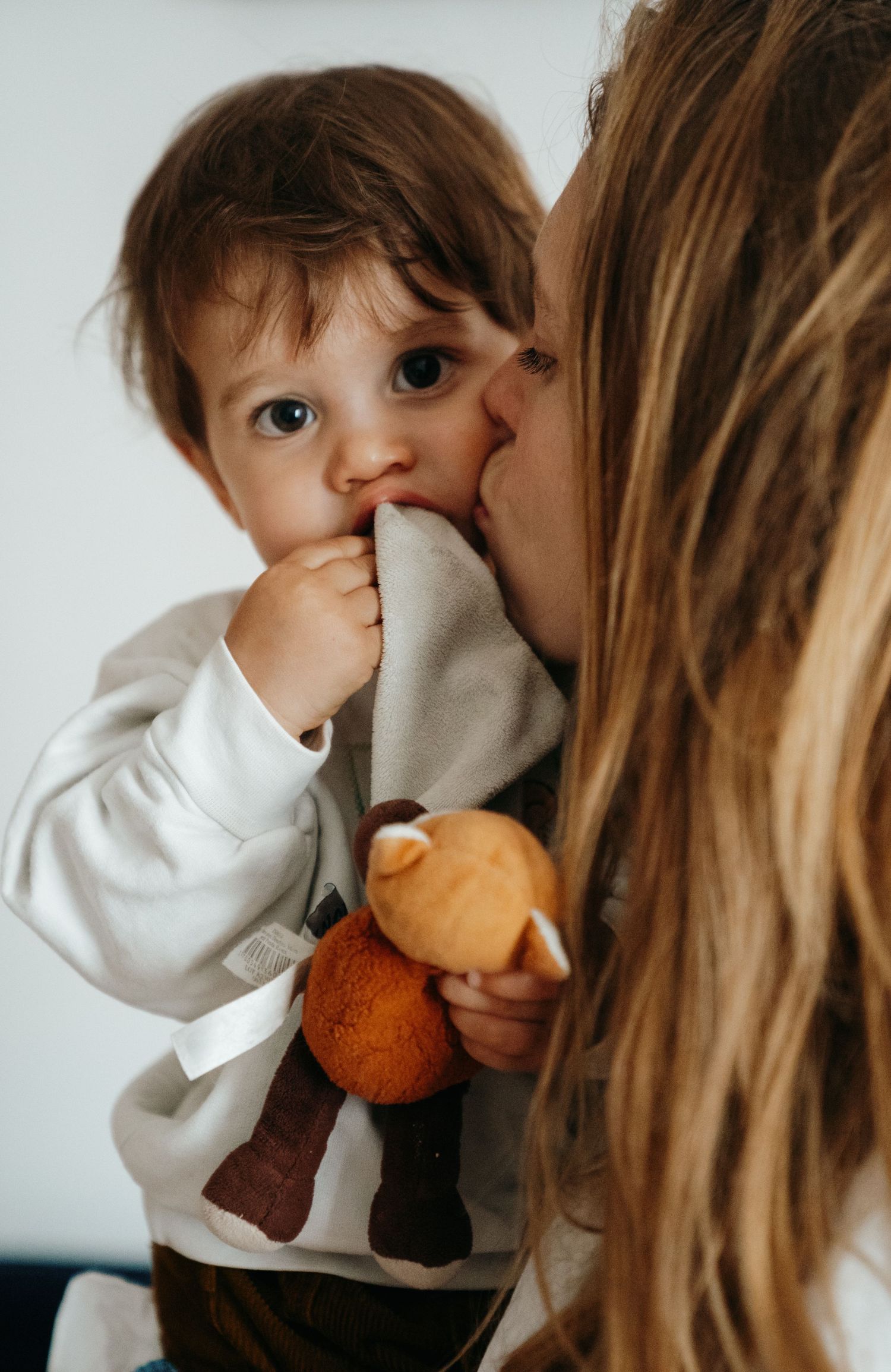 Mère embrassant son jeune garçon tenant une peluche