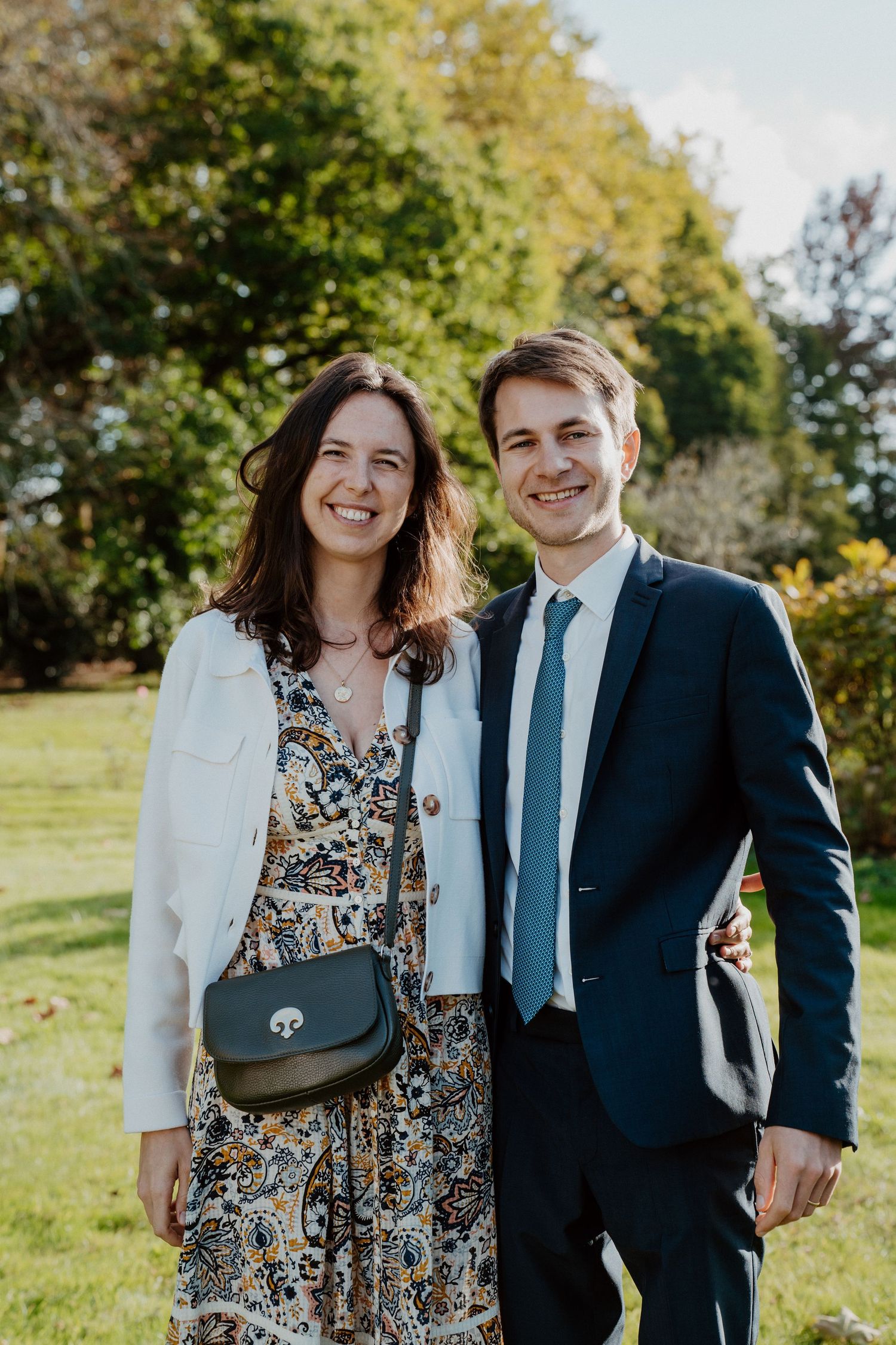 Couple d'invités posant ensemble dans le jardin du château