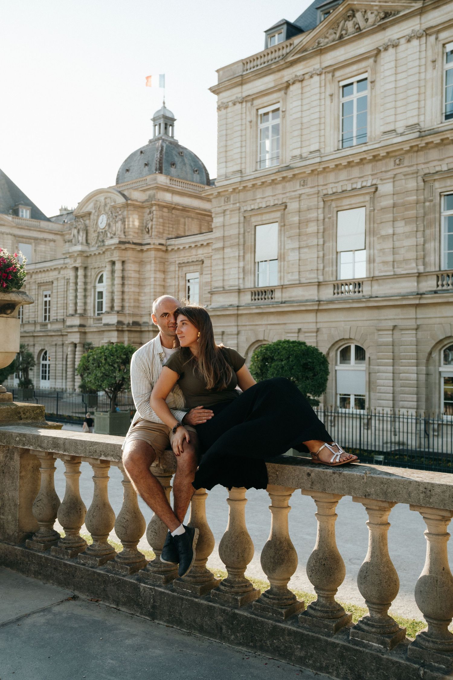 Couple posant devant le palais du Luxembourg à Paris