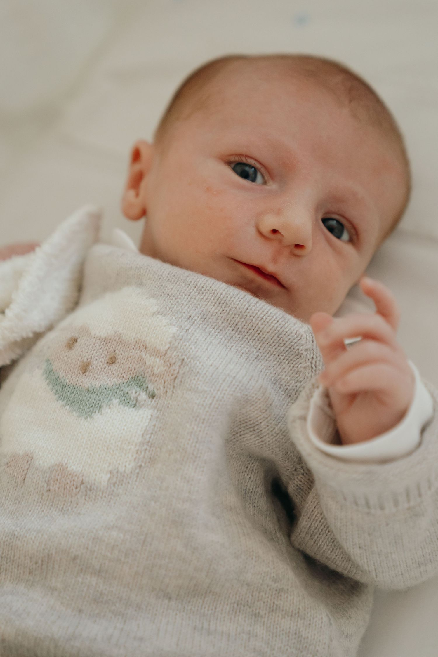 Portrait rapproché d'un nouveau-né éveillé en pull tricoté