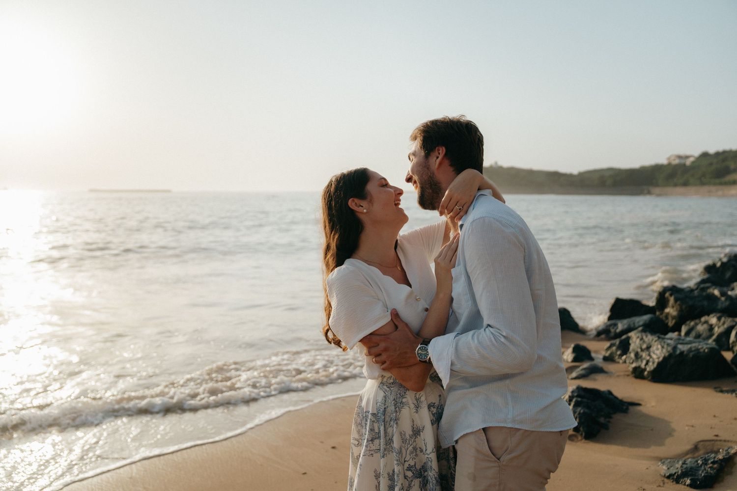Couple s'enlaçant sur une plage au coucher du soleil à Saint Jean de Luz