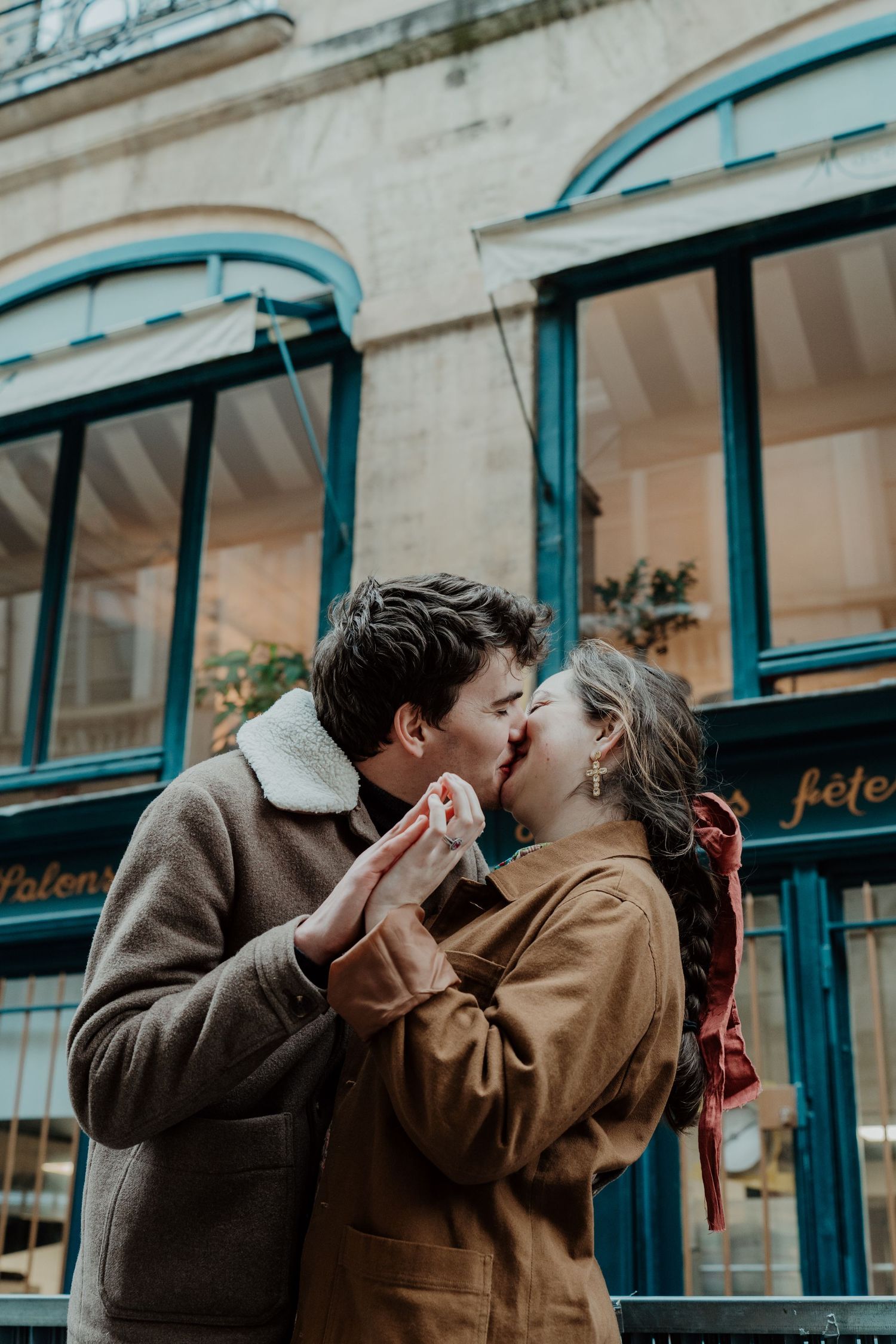 Mariés s'embrassant devant une façade colorée