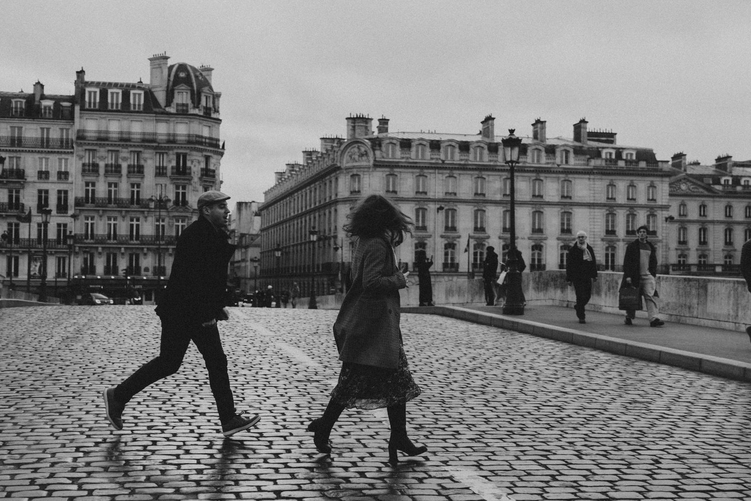 Couple marchant dans une rue pavée, noir et blanc