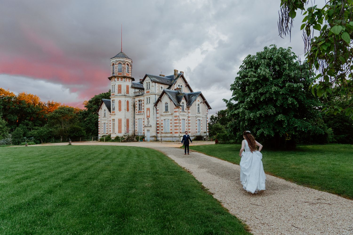 Mariée marchant vers un château au coucher du soleil